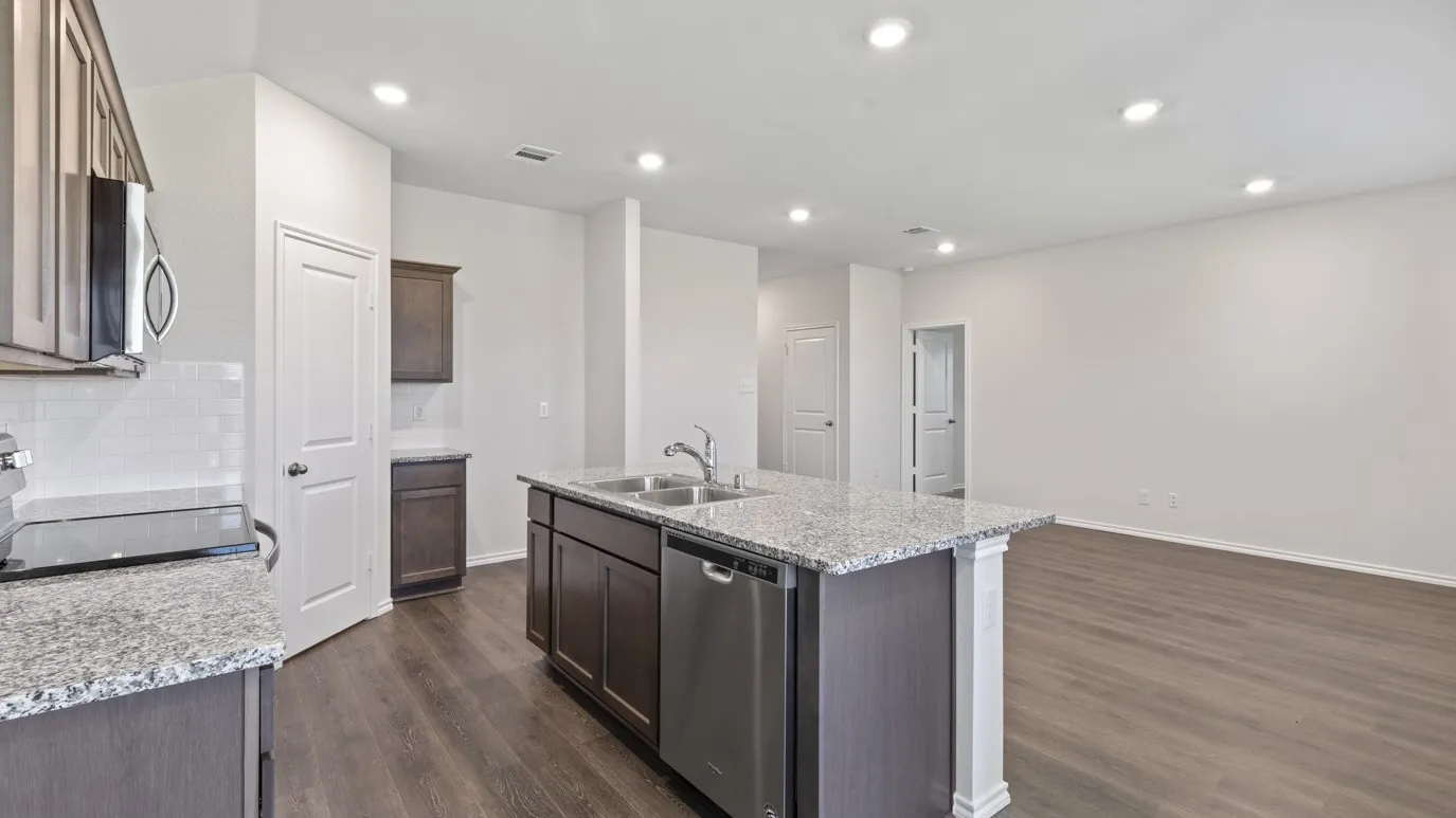 Kitchen featuring granite countertops, stainless steel appliances, wood-finish flooring, white subway tile backsplash, and recessed lighting