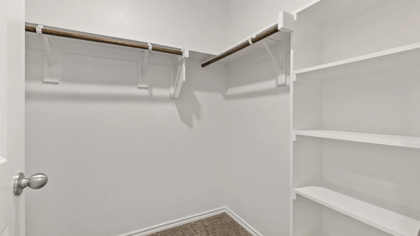 Built-in shelving, two clothing rods, and textured wall finish
