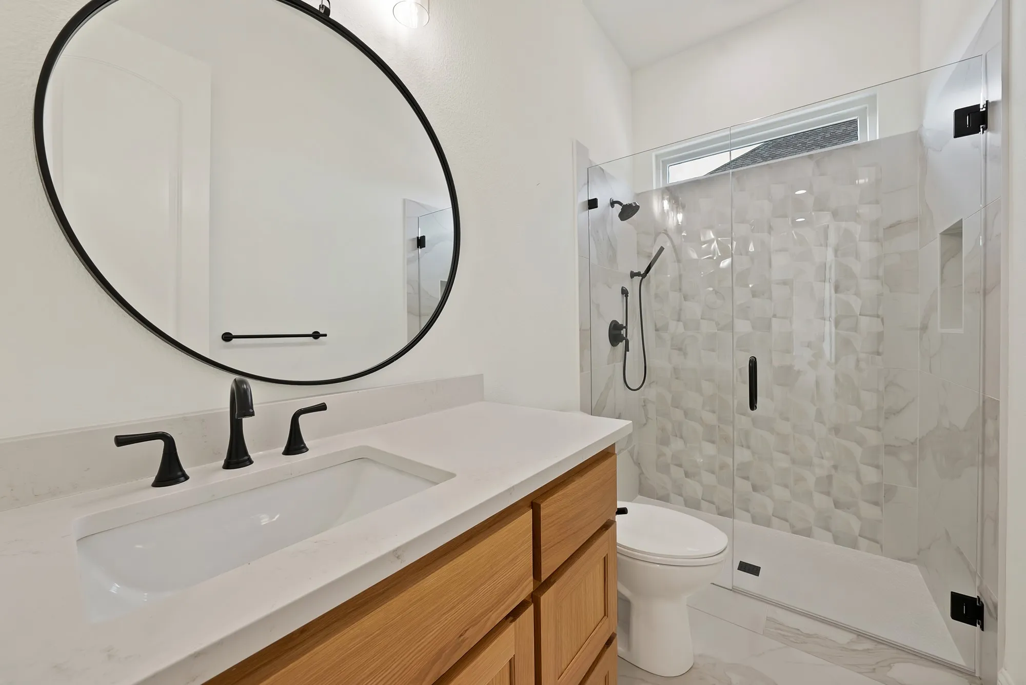 Light wood-finish vanity with an integrated sink and matte black fixtures