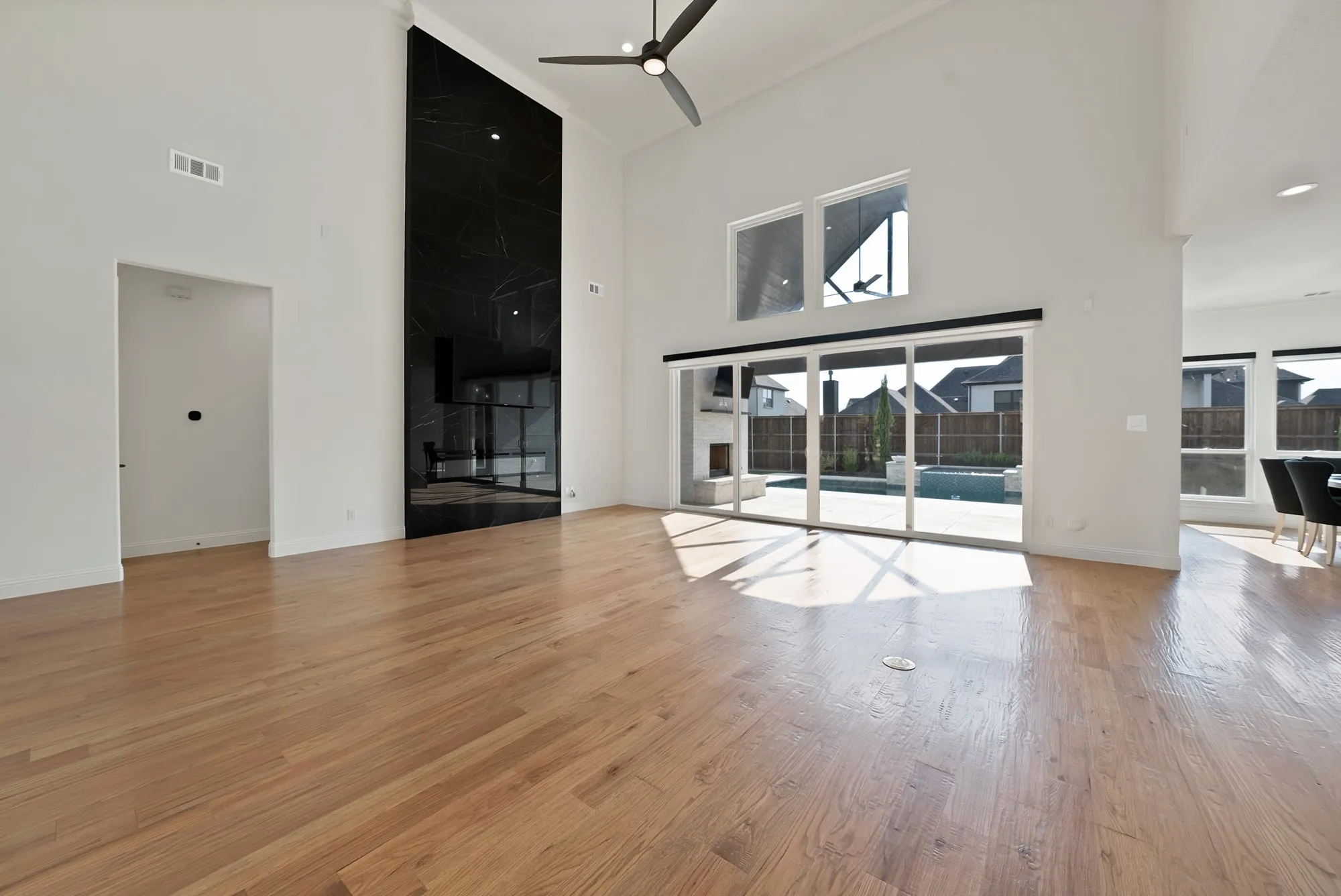 Hardwood flooring throughout, vaulted ceilings, and a floor-to-ceiling black stone accent wall
