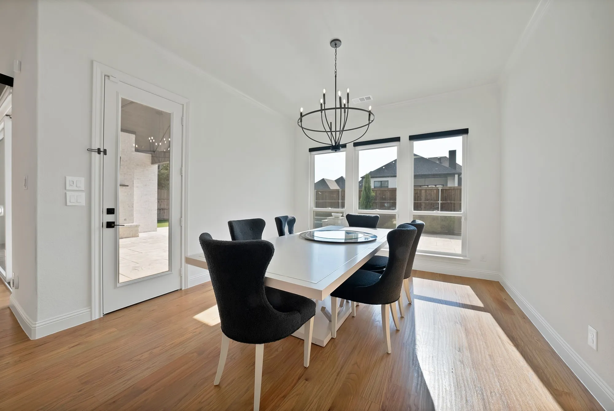 Hardwood-finish flooring, a contemporary chandelier, multiple transom windows, and a glass-paneled door