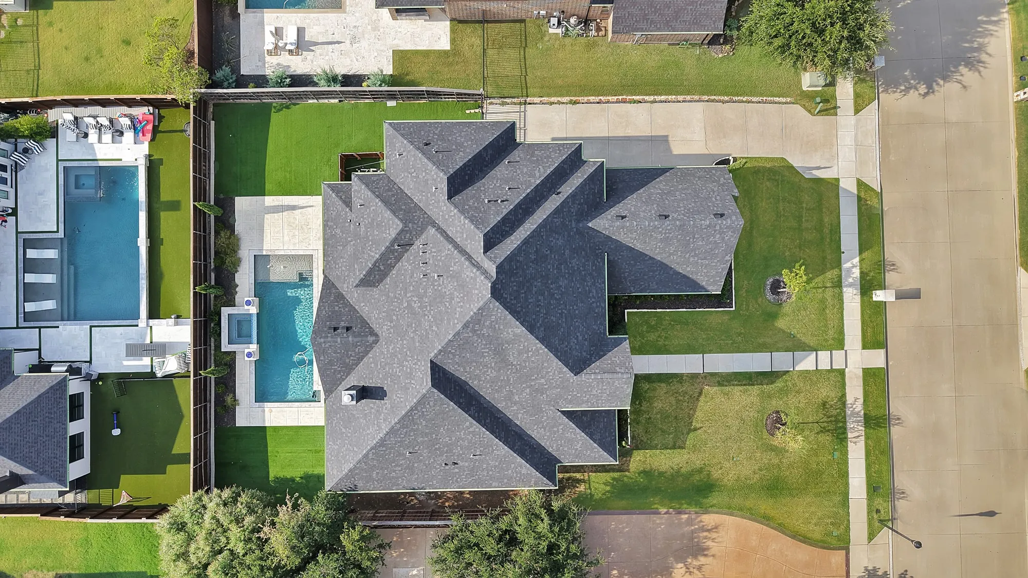 Expansive property featuring a multi-gabled roofline, a private pool, and an integrated spa
