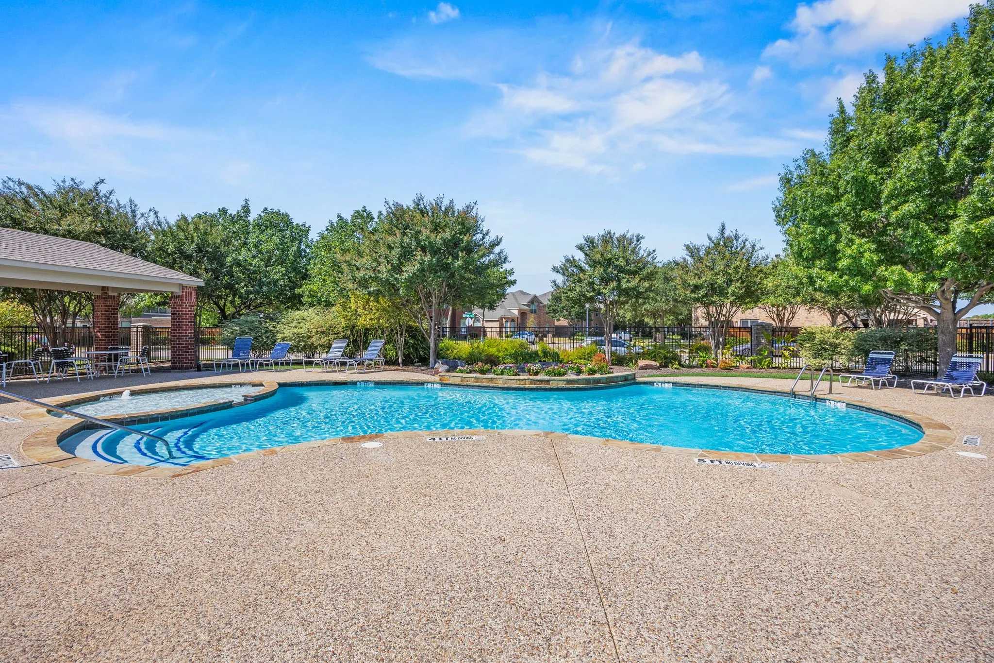 Swimming pool with an integrated spa, surrounded by a textured concrete deck