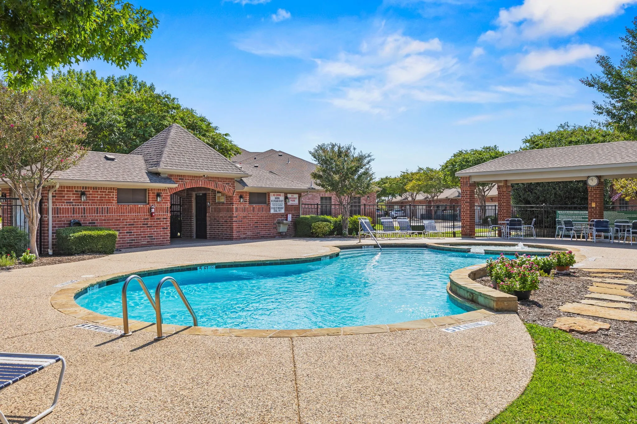 Resort-style pool with integrated spa and surrounding aggregate concrete decking