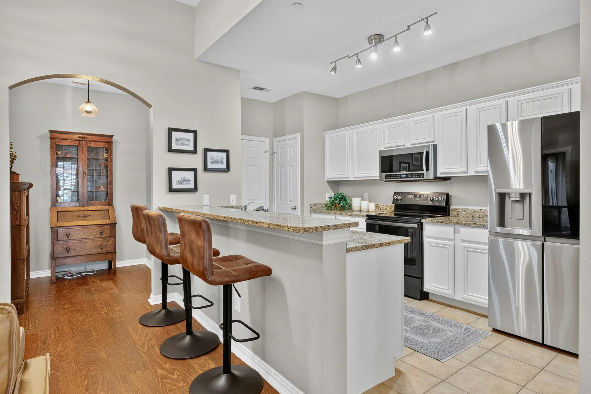 Kitchen featuring white cabinetry, stainless steel appliances, and stone-finish countertops