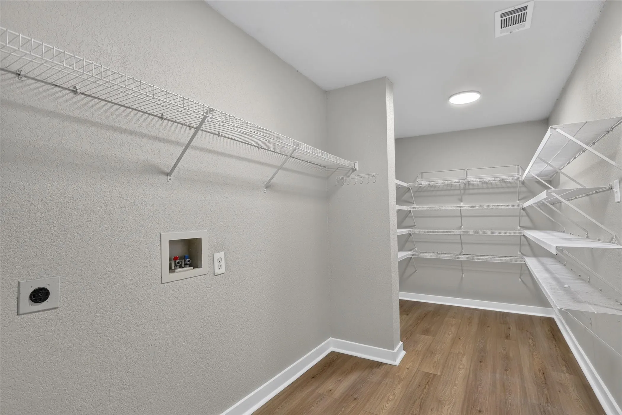 Laundry area with wood-finish flooring