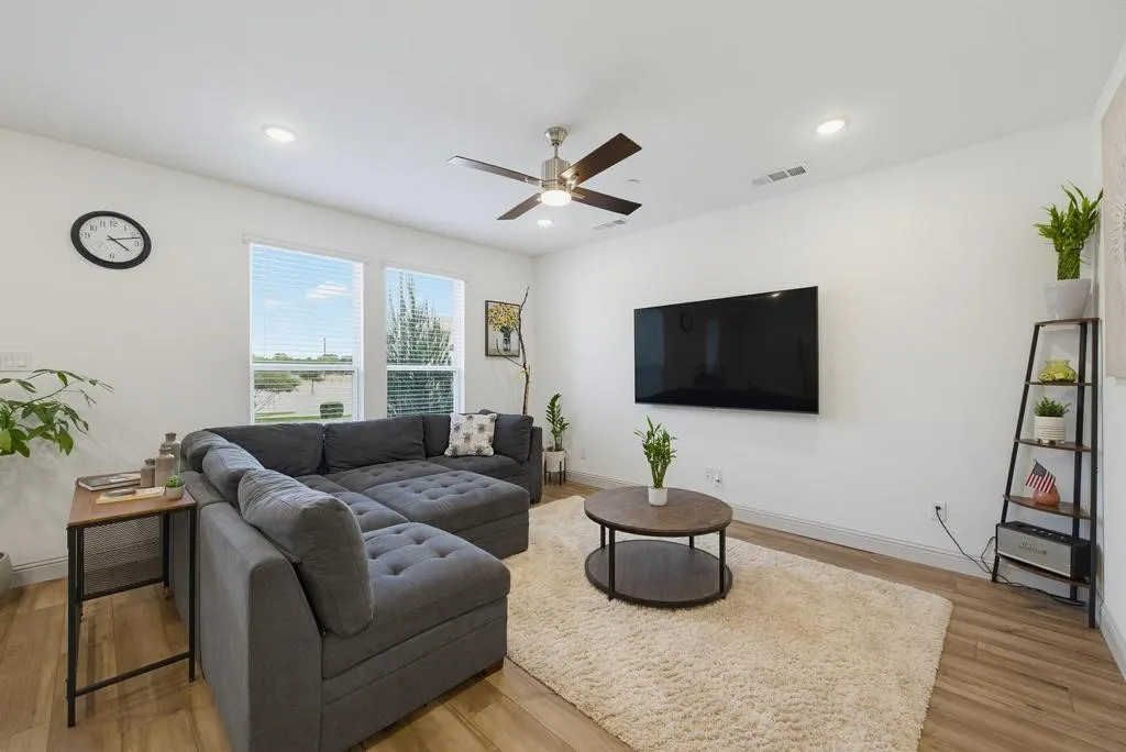 Open-concept living space with wood-finish flooring, recessed lighting, and a ceiling fan