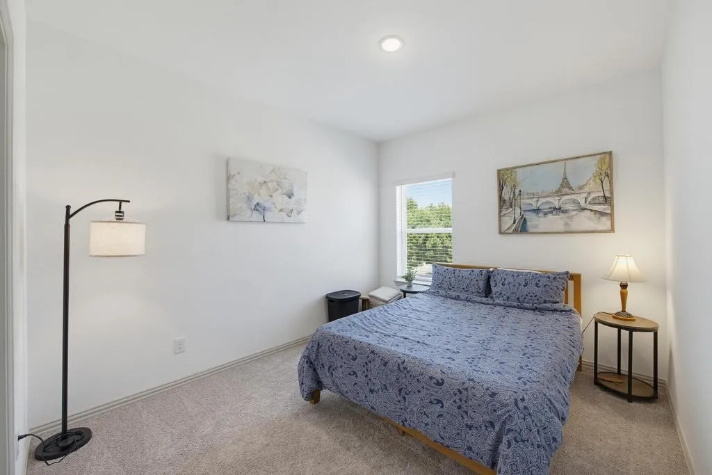 Recessed ceiling lighting, a window with blinds, and light gray carpeting