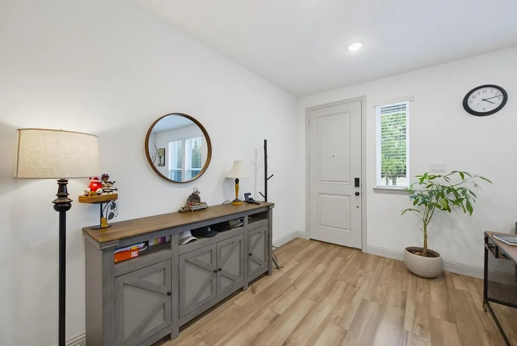 Wood-finish flooring, recessed lighting, and a front entry door with a privacy window