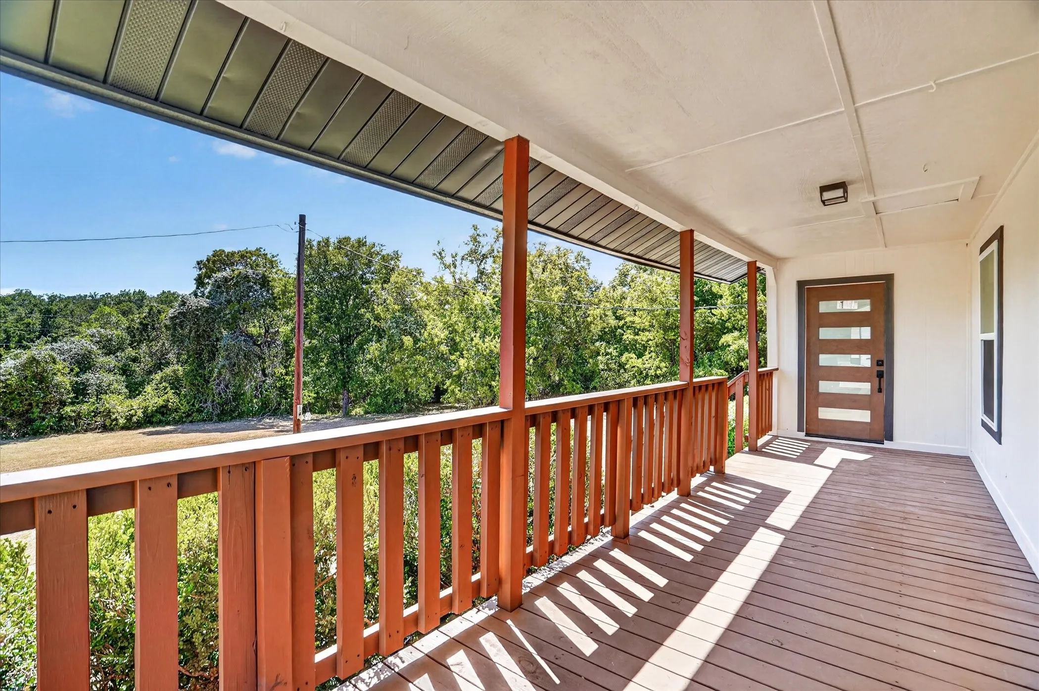 Covered porch featuring wood-finish decking and railing