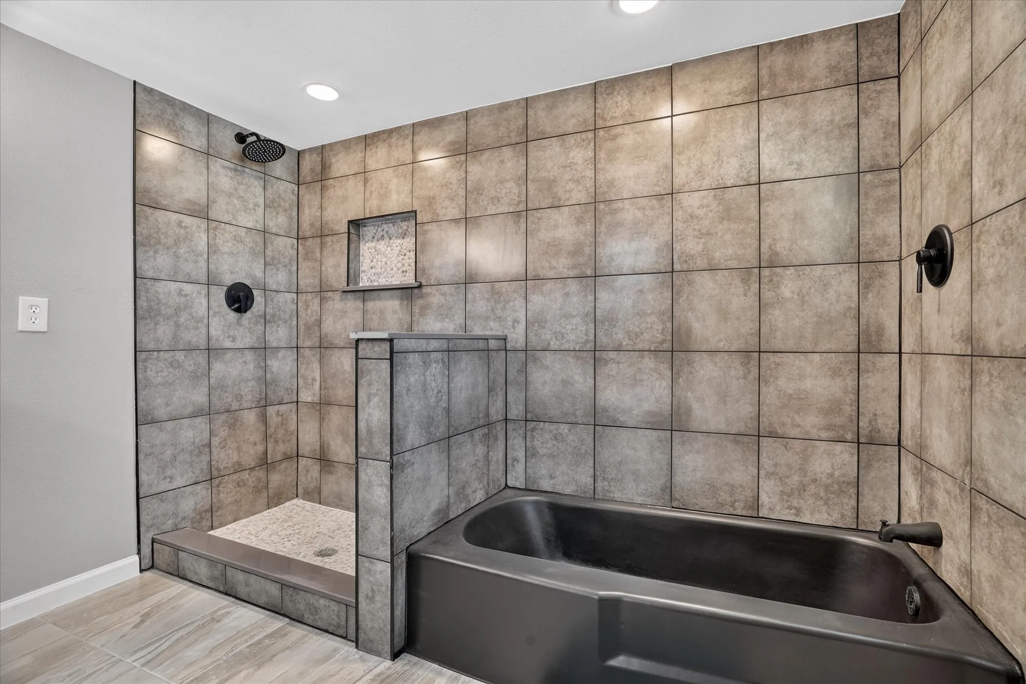 Walk-in shower with tiled walls and floor, complete with a built-in niche and rainfall showerhead