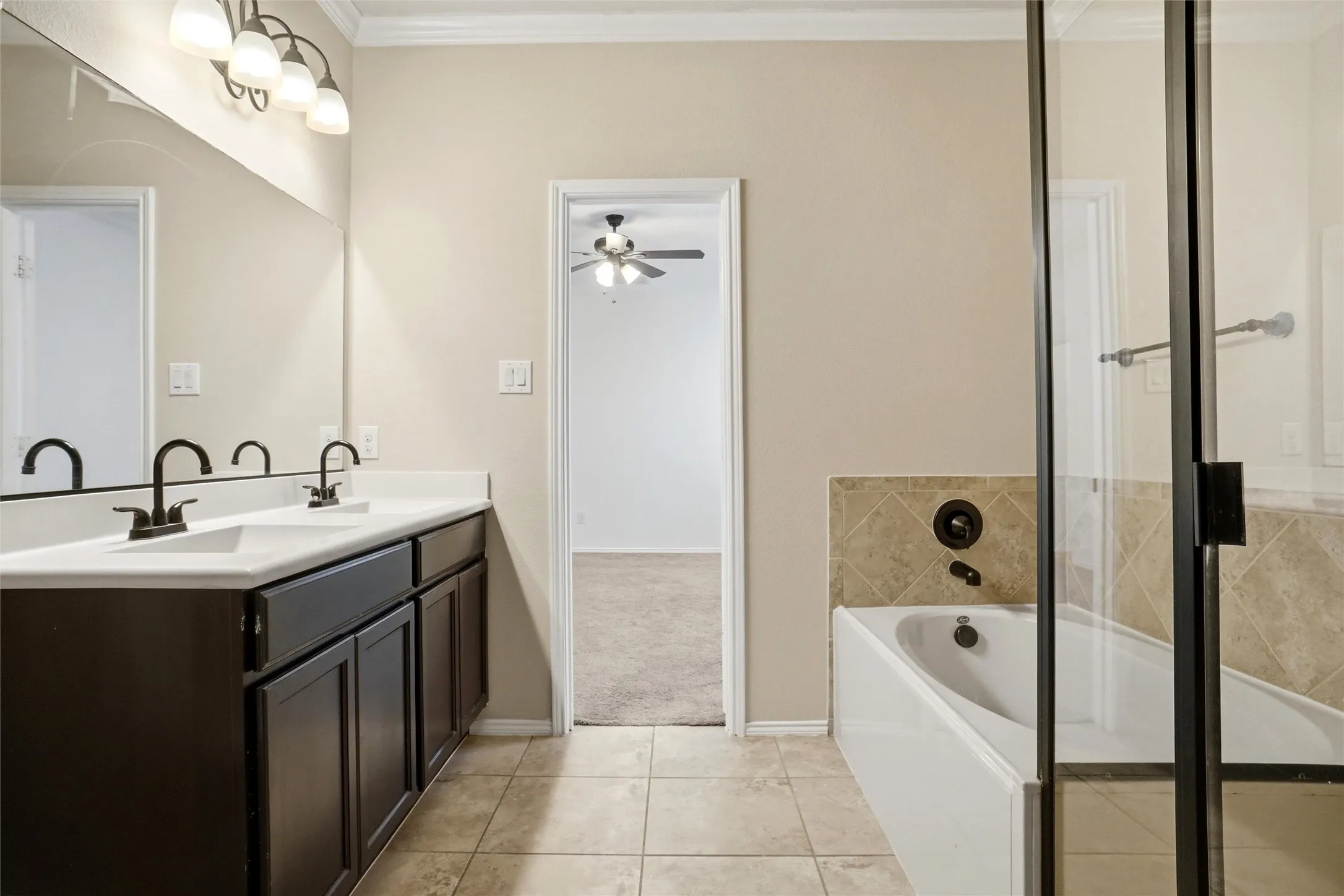 Dual vanity with dark wood cabinetry, white countertops, and matte black fixtures