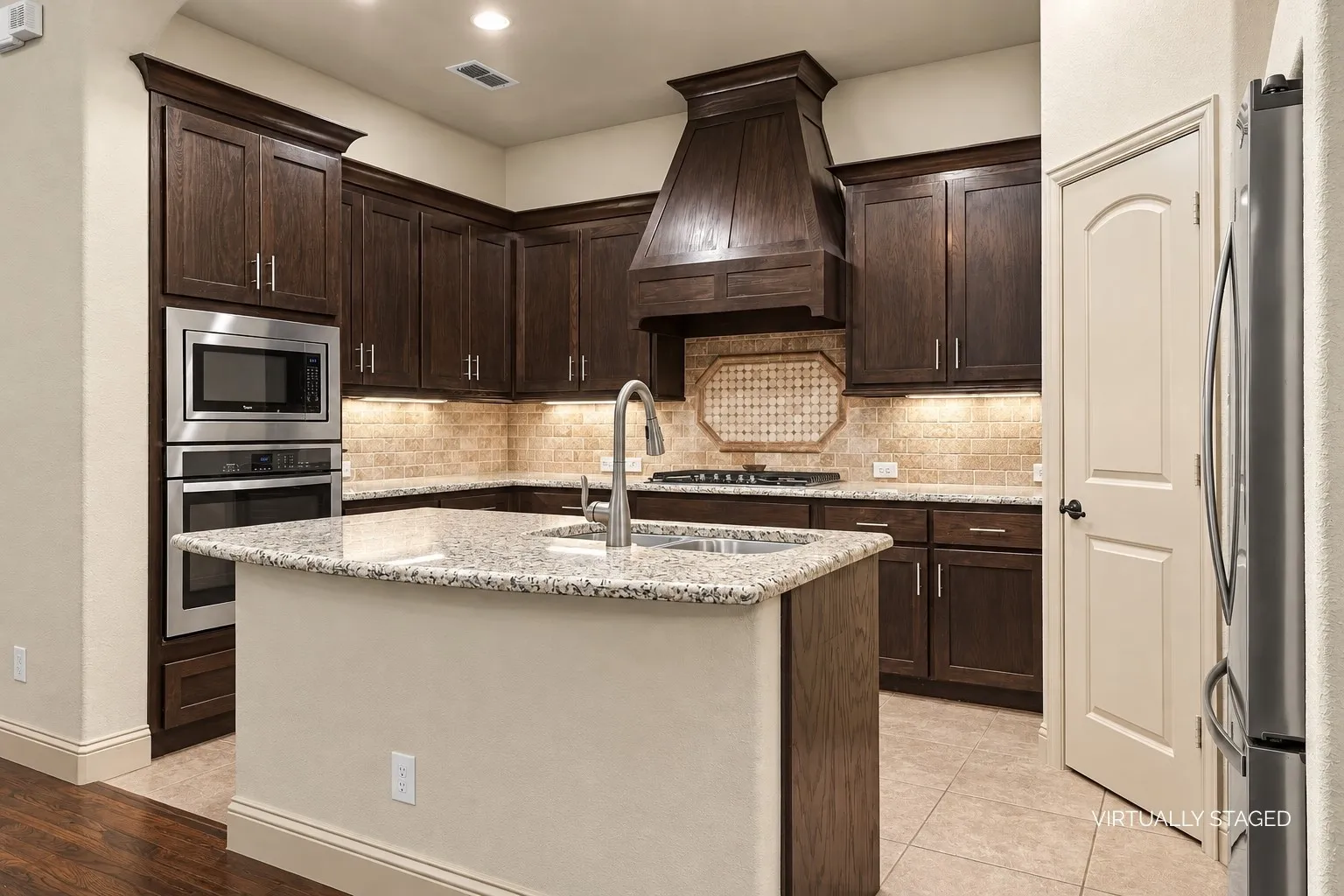 Kitchen with island, stacked microwave oven, upper x under cabinet lighting, walk-in pantry, and breakfast bar