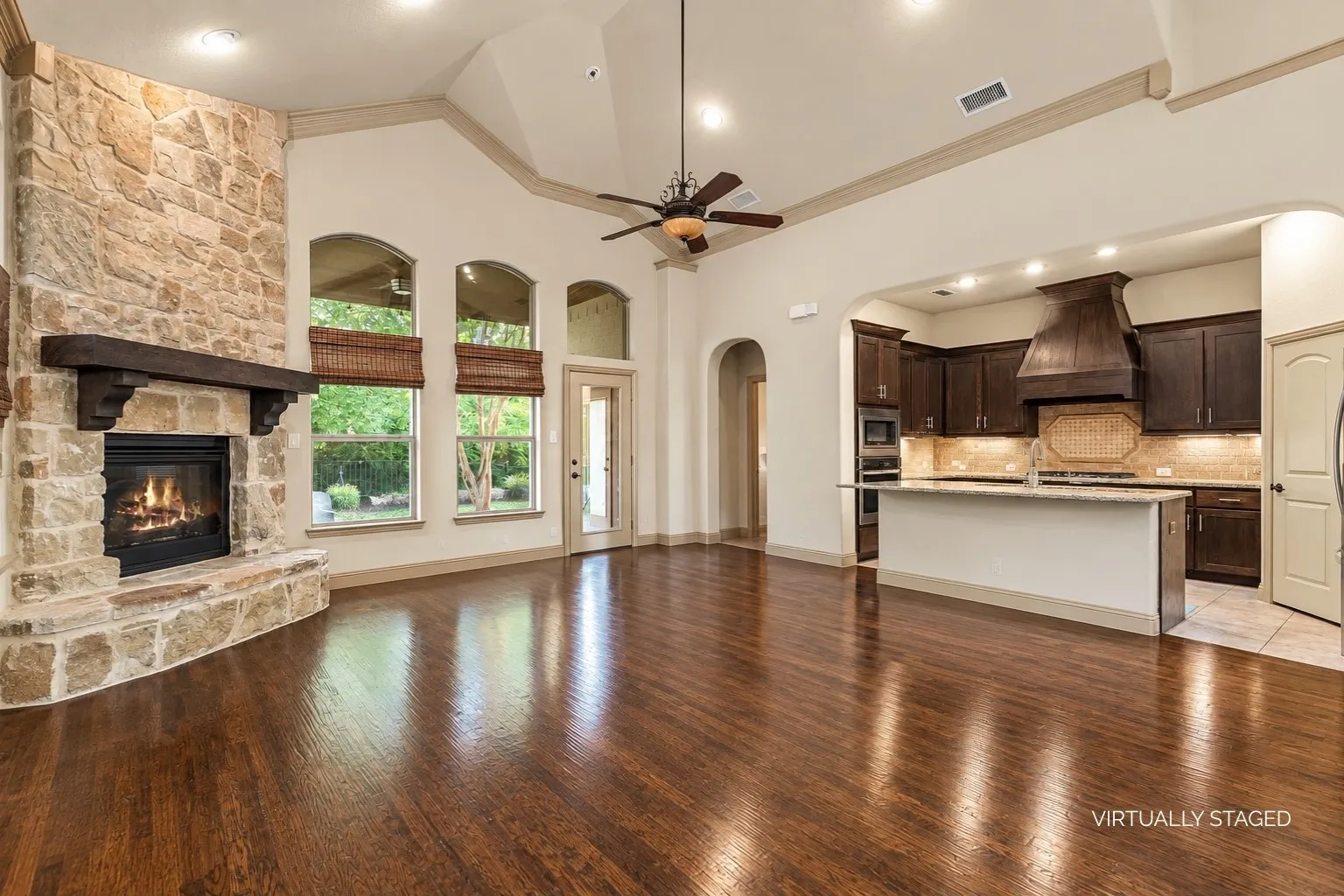 Floor to ceiling stone fireplace in living room with kitchen overlooking the space