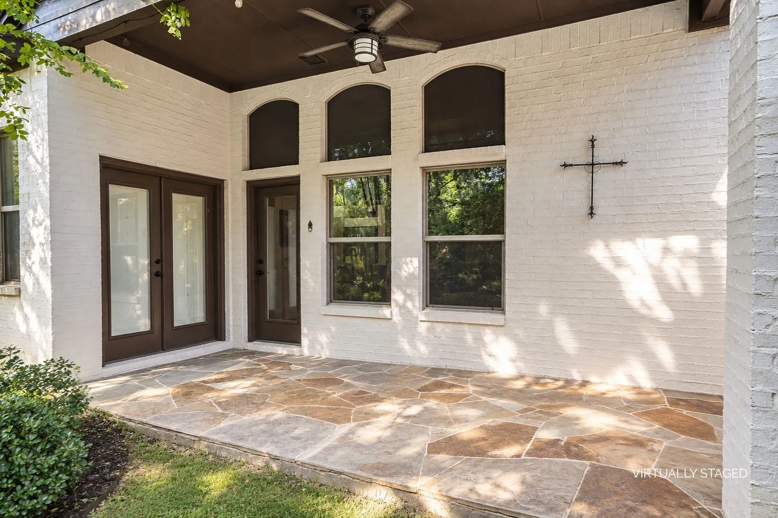 Beautiful private backyard covered patio with ceiling fan and seating space