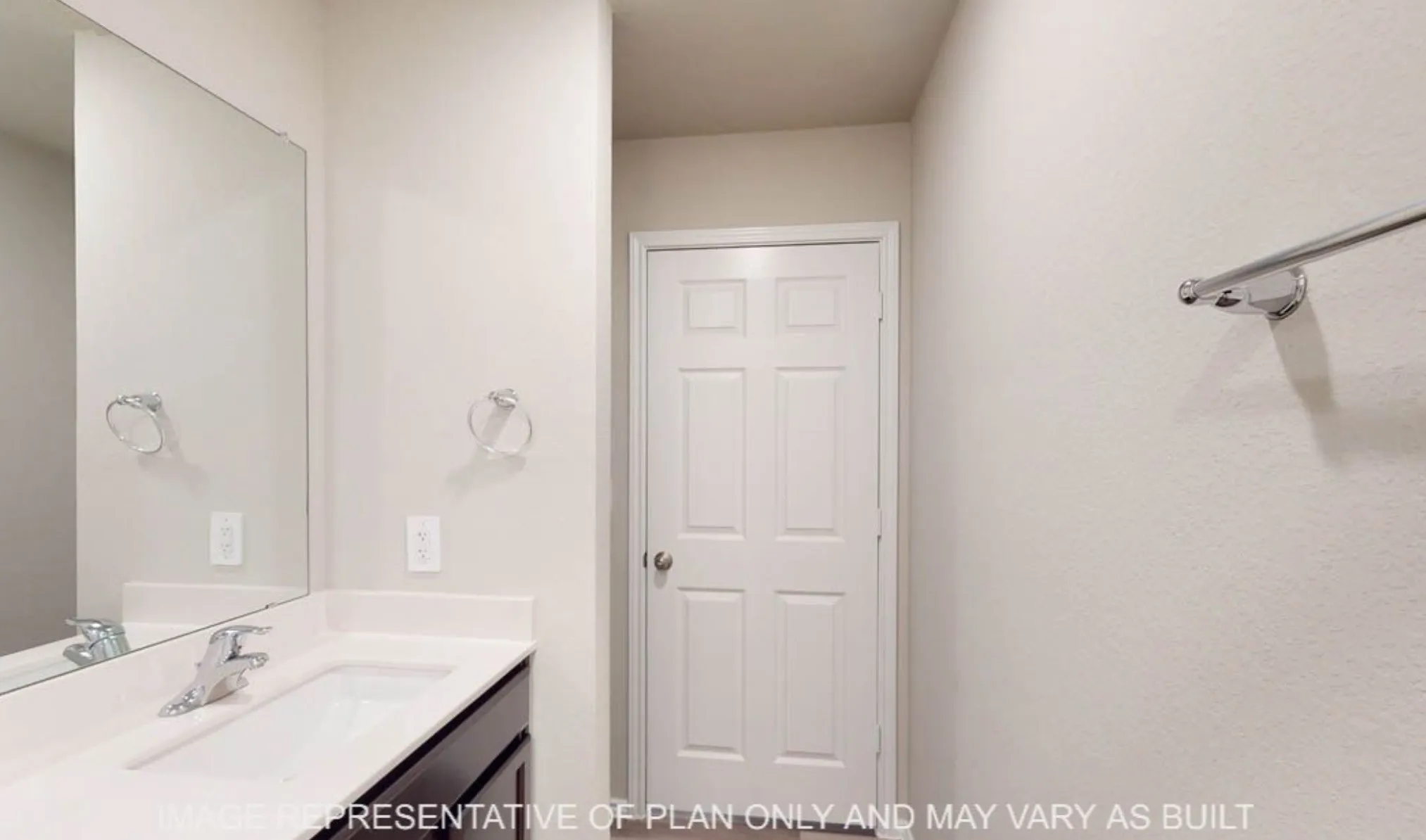 Vanity with an integrated sink, polished chrome faucet, and a large wall-mounted mirror