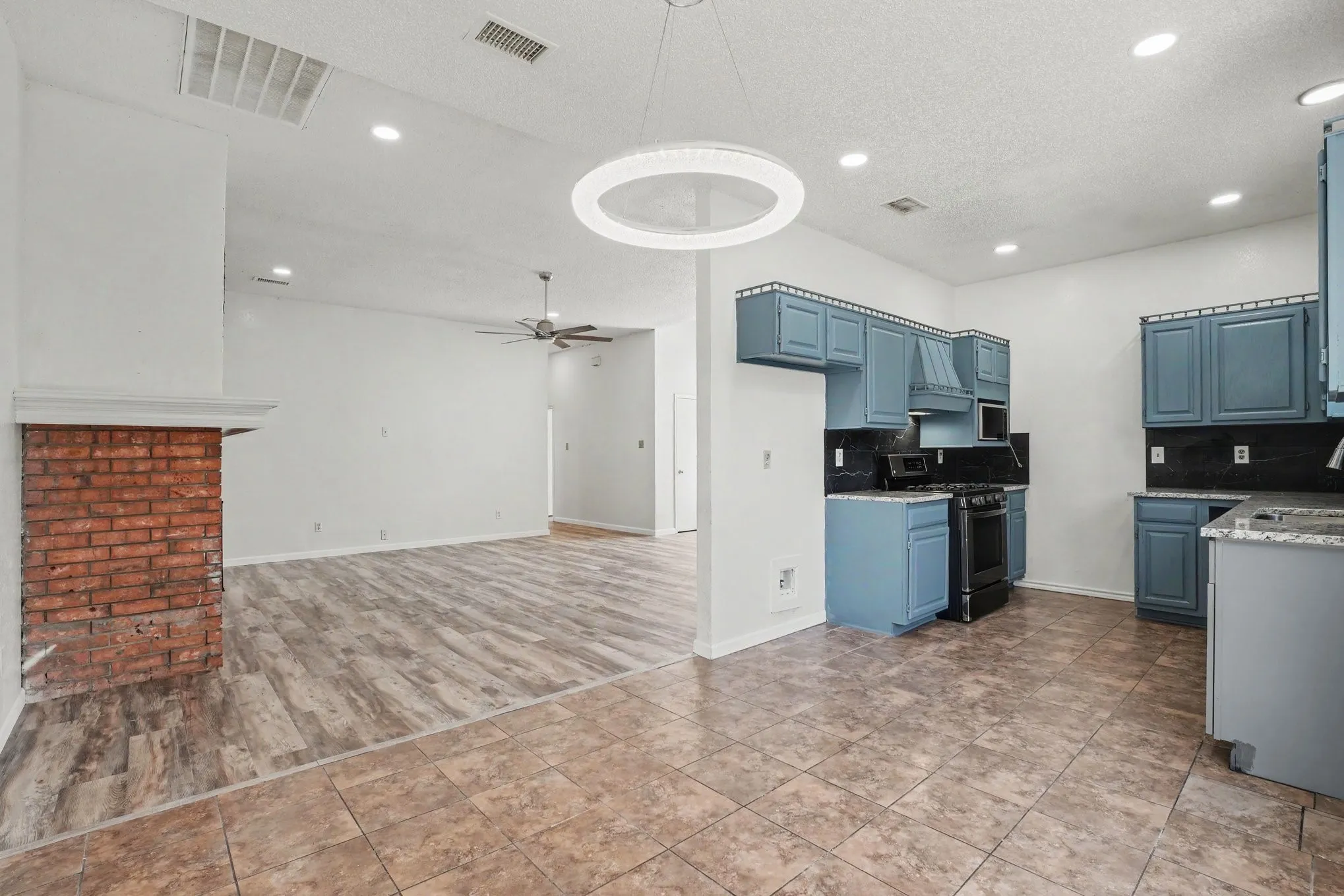 Dining area and kitchen with wood-finish flooring, recessed lighting, and a ceiling fan