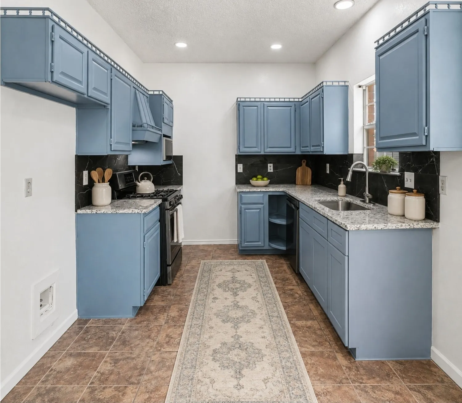 AI Staging. Spacious kitchen featuring blue cabinetry, granite-style countertops, dark backsplash, a built-in sink, and tile flooring