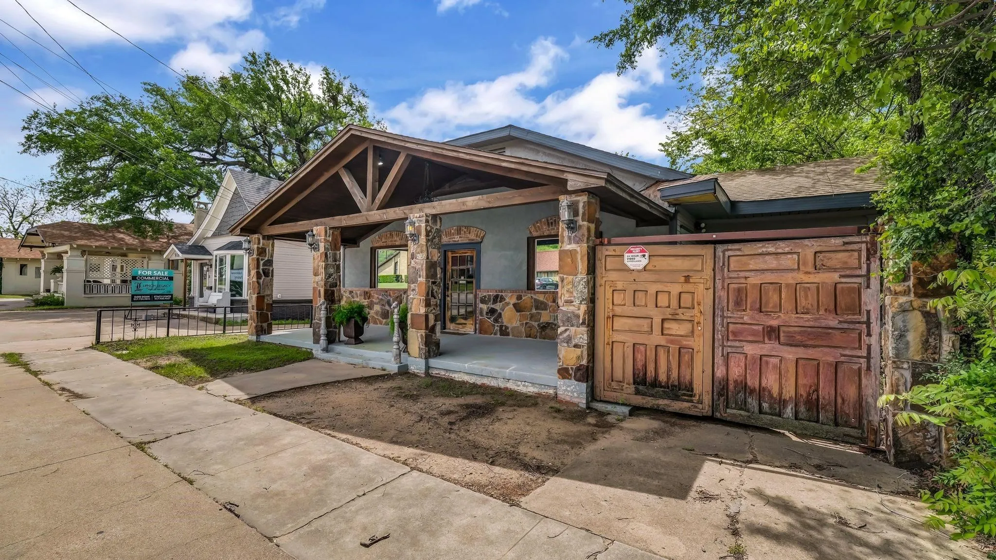 Stone veneer exterior with a covered front porch featuring exposed wood beams and columns