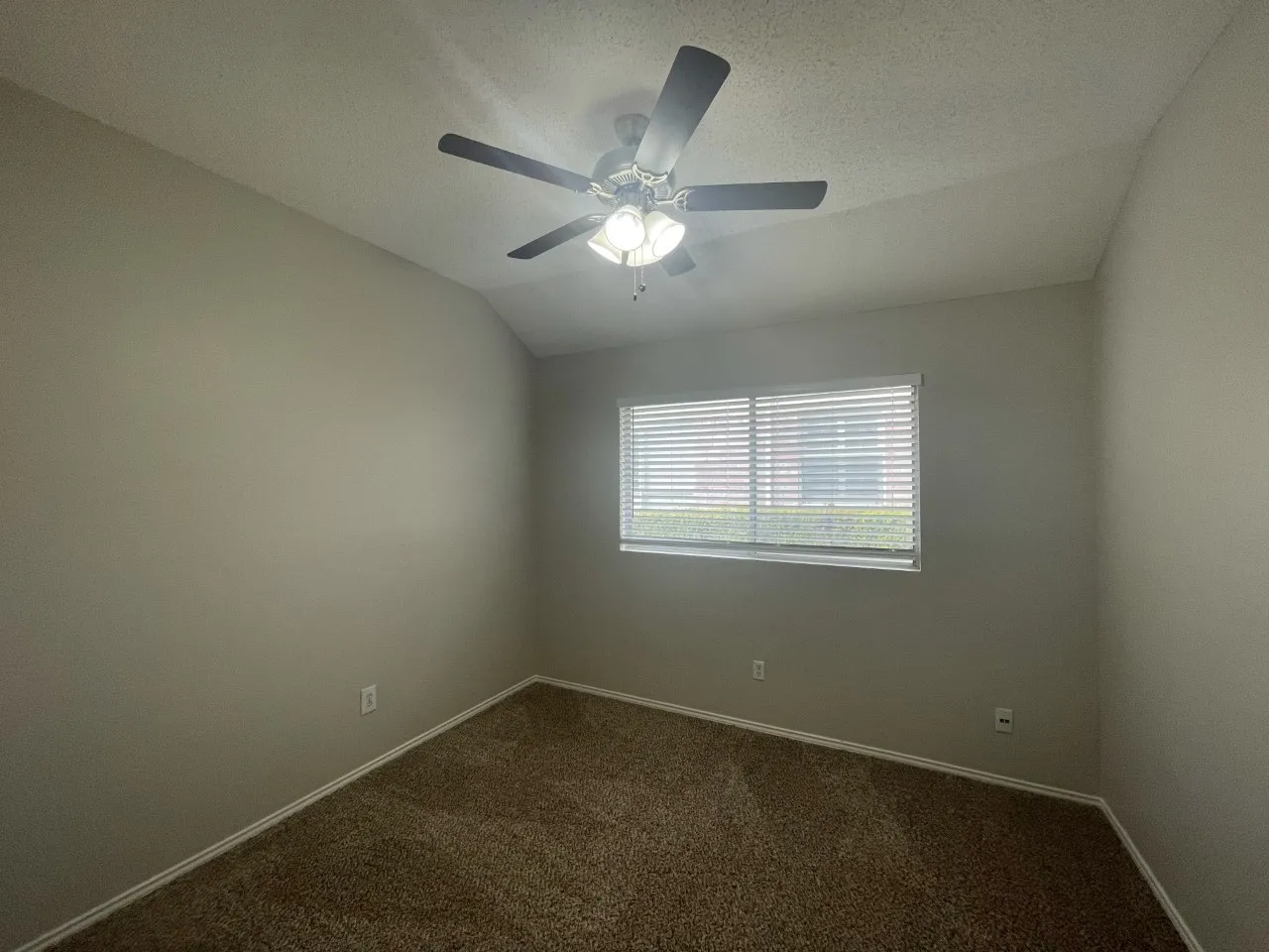 Recessed window with horizontal blinds, overhead ceiling fan with lighting, and neutral wall paint