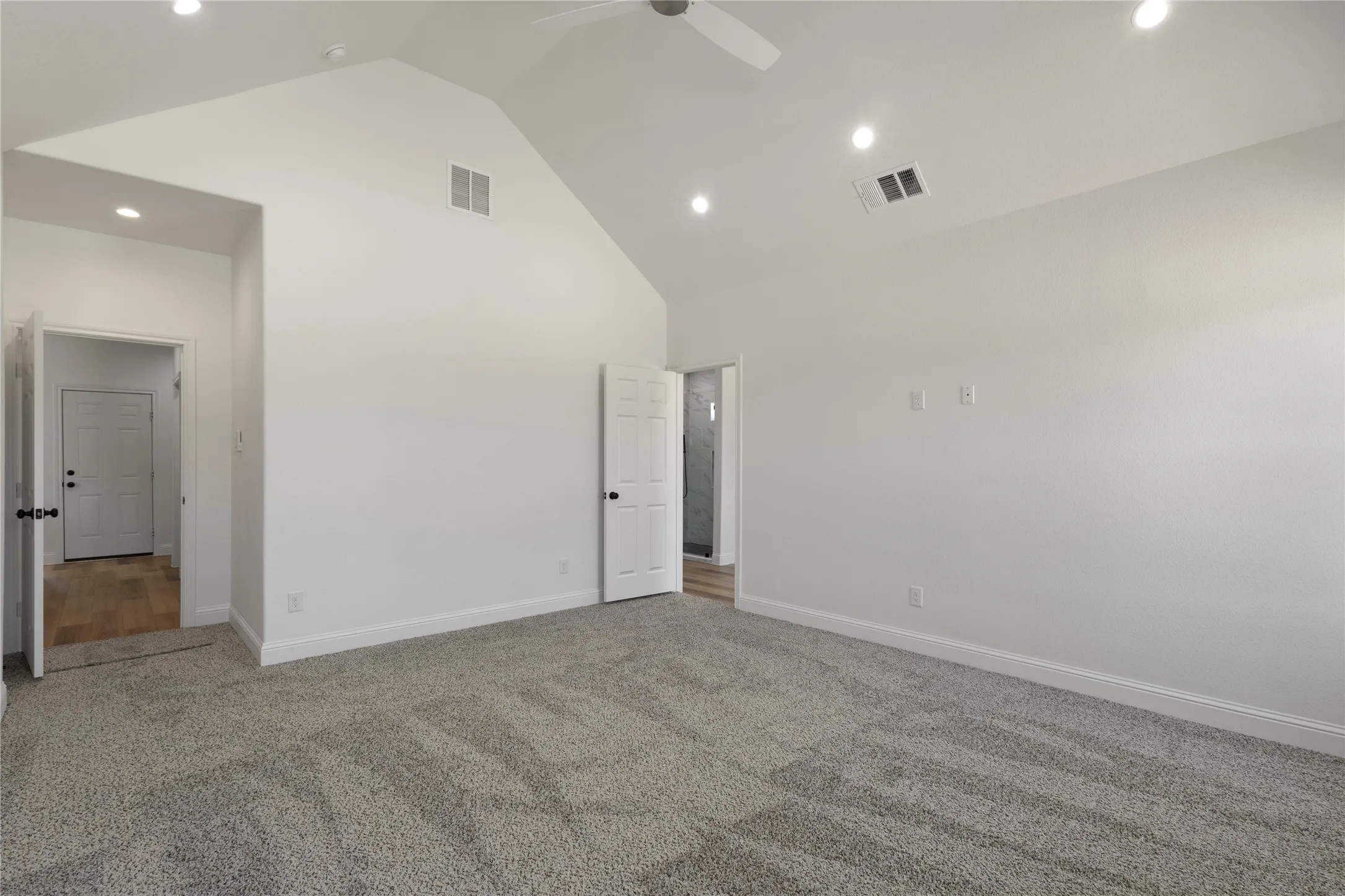 Integrated shelving system, multiple hanging rods, recessed ceiling lighting, textured carpet flooring, and white trim work