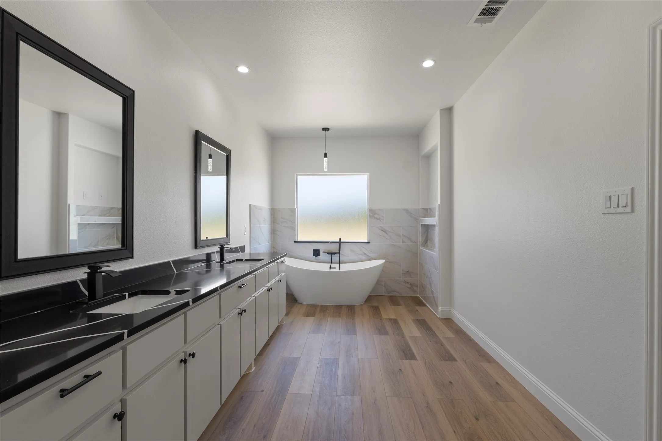 Dual vanity with sleek black countertops and integrated sinks