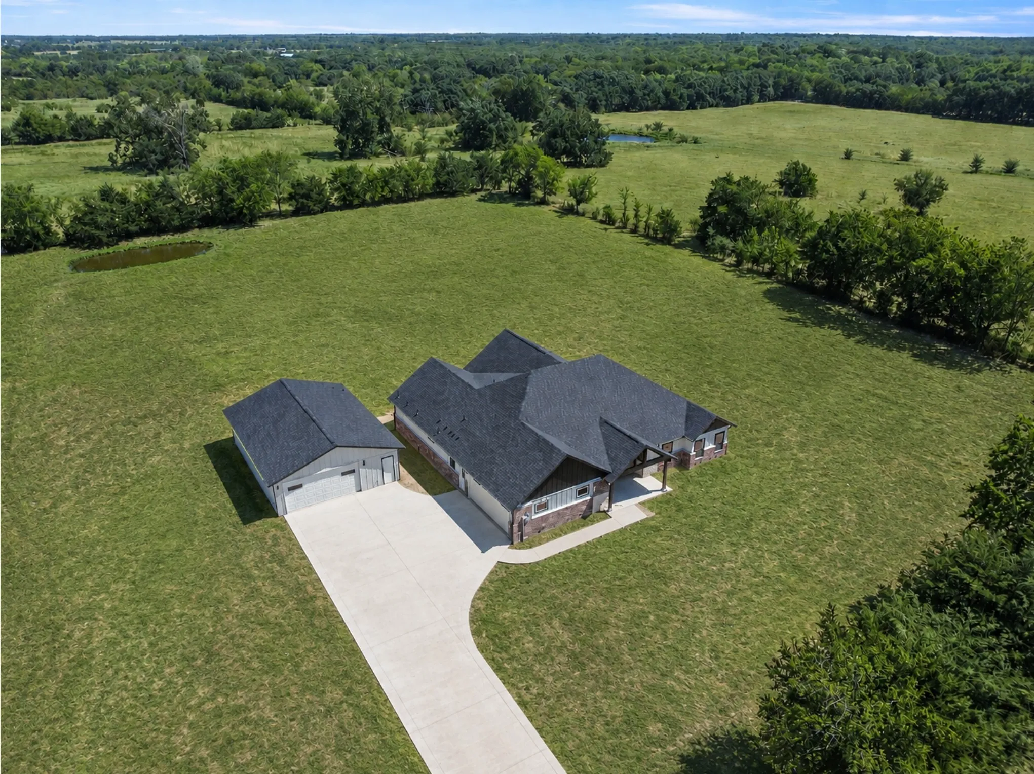 Expansive green landscape with a private pond