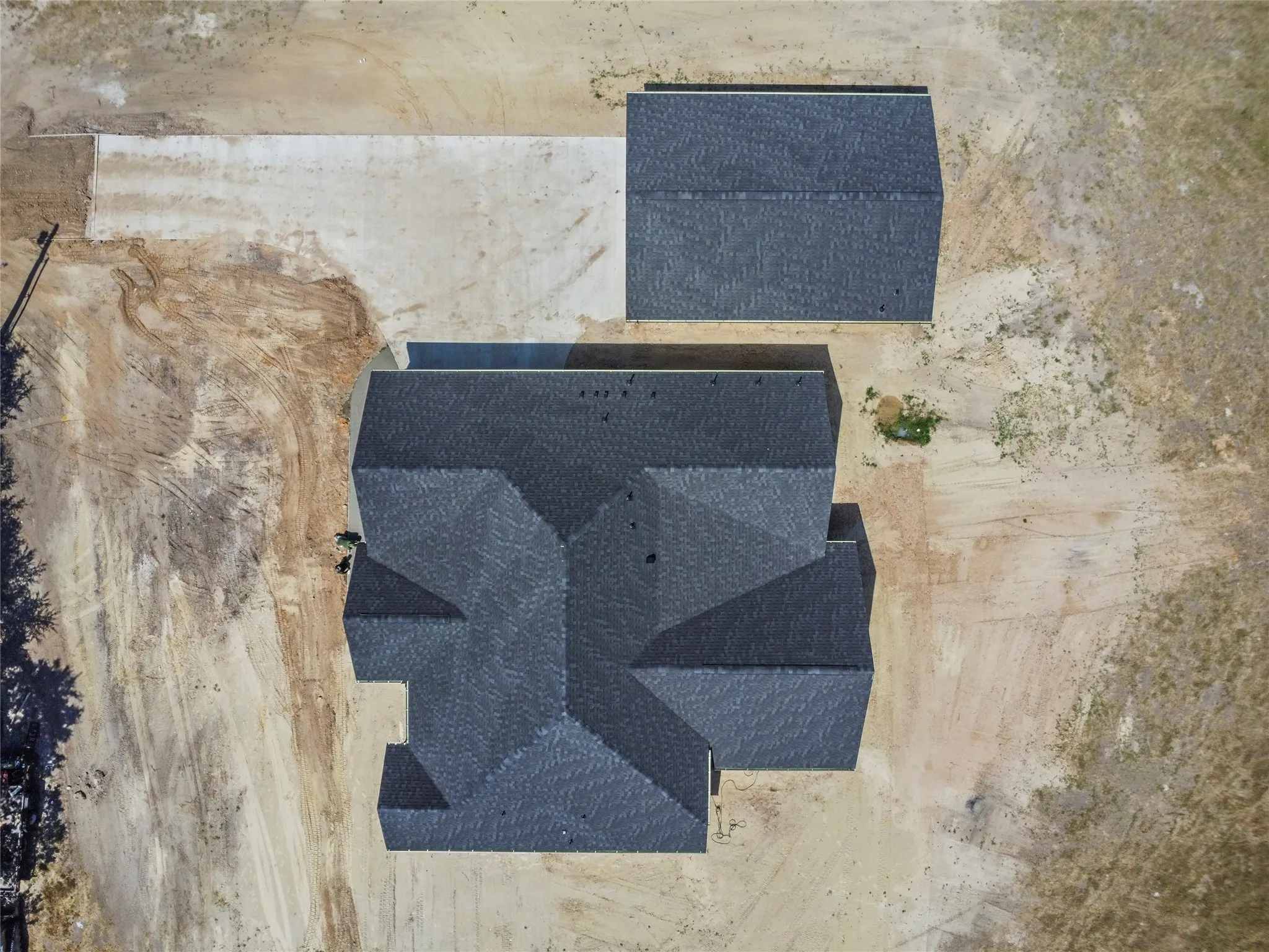 Newly constructed property featuring a main residence with a multi-gabled roofline and an accessory structure
