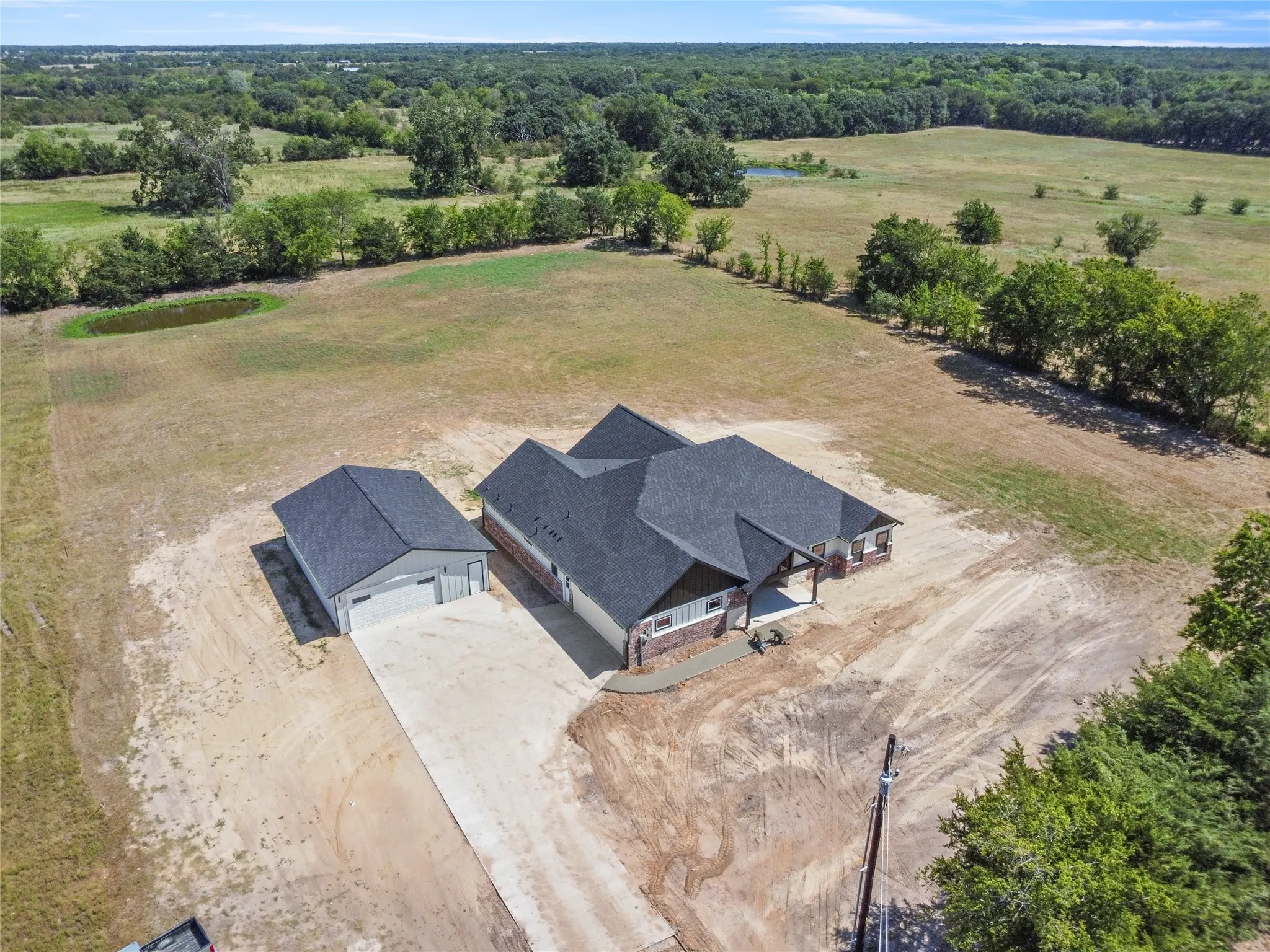 Newly constructed residence situated on expansive acreage with mature tree lines and pastoral surroundings