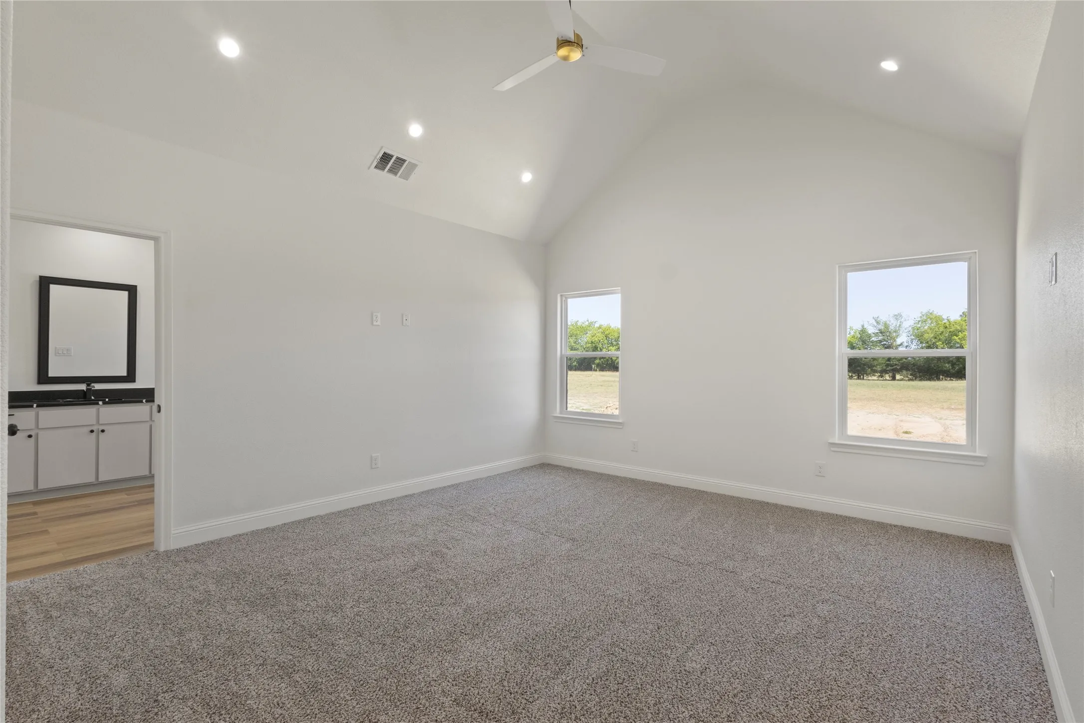 Recessed ceiling fan with light fixture, dual pane windows, and neutral carpet
