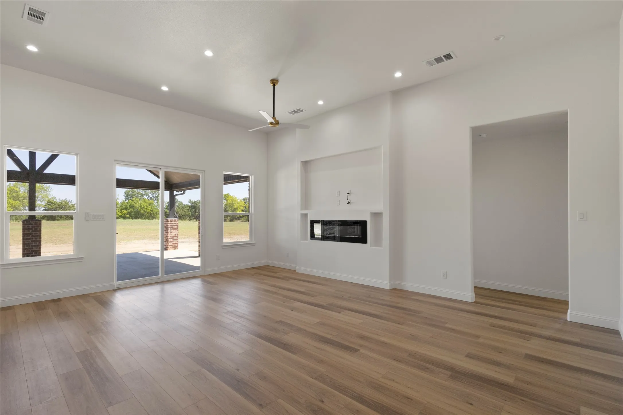Spacious two-car garage with overhead door mechanism, concrete flooring, recessed lighting, and two windows