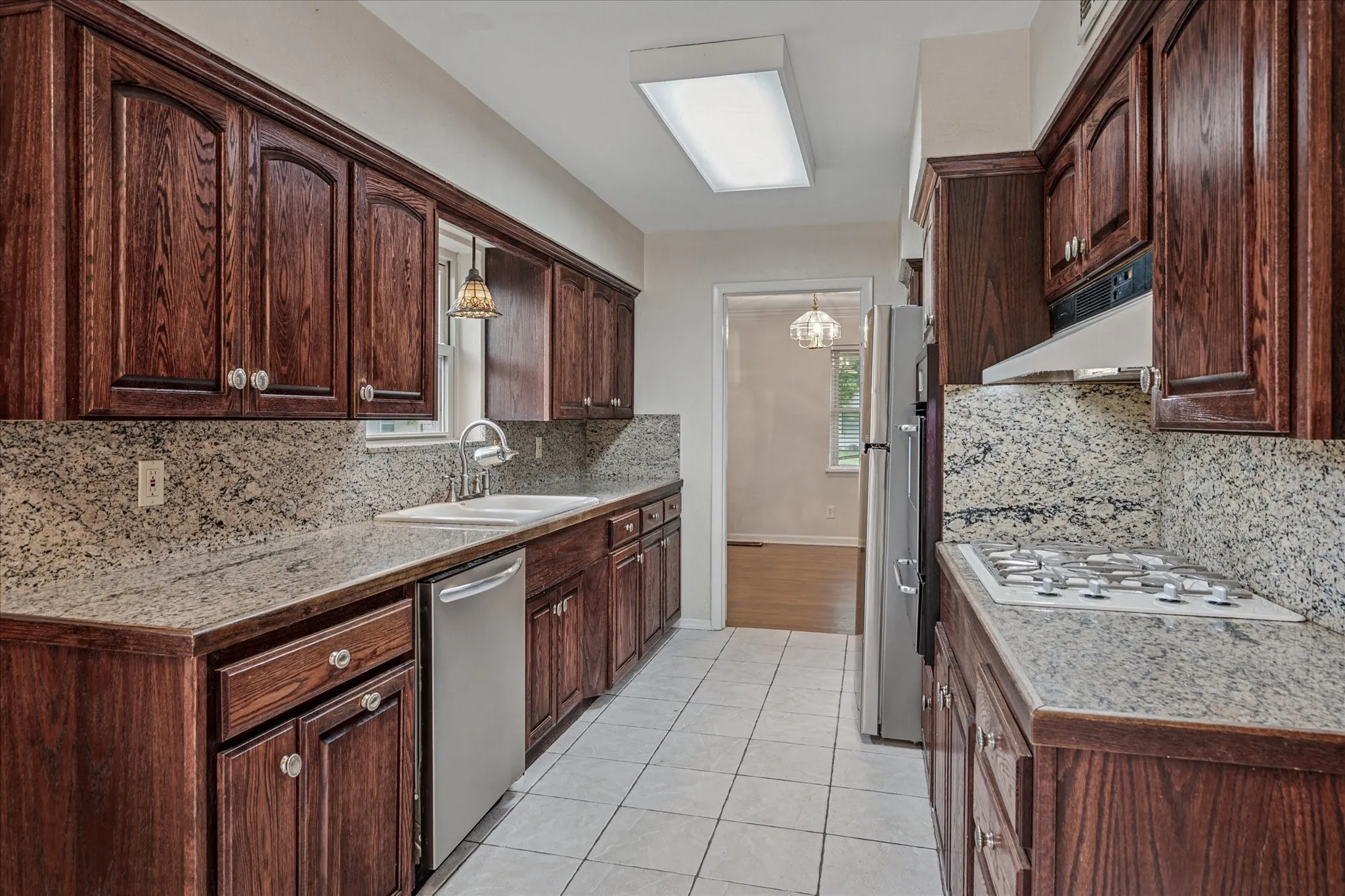 All stainless, eat-in galley kitchen with broiler, gas cook top, solid wood cabs, and granite tile.
