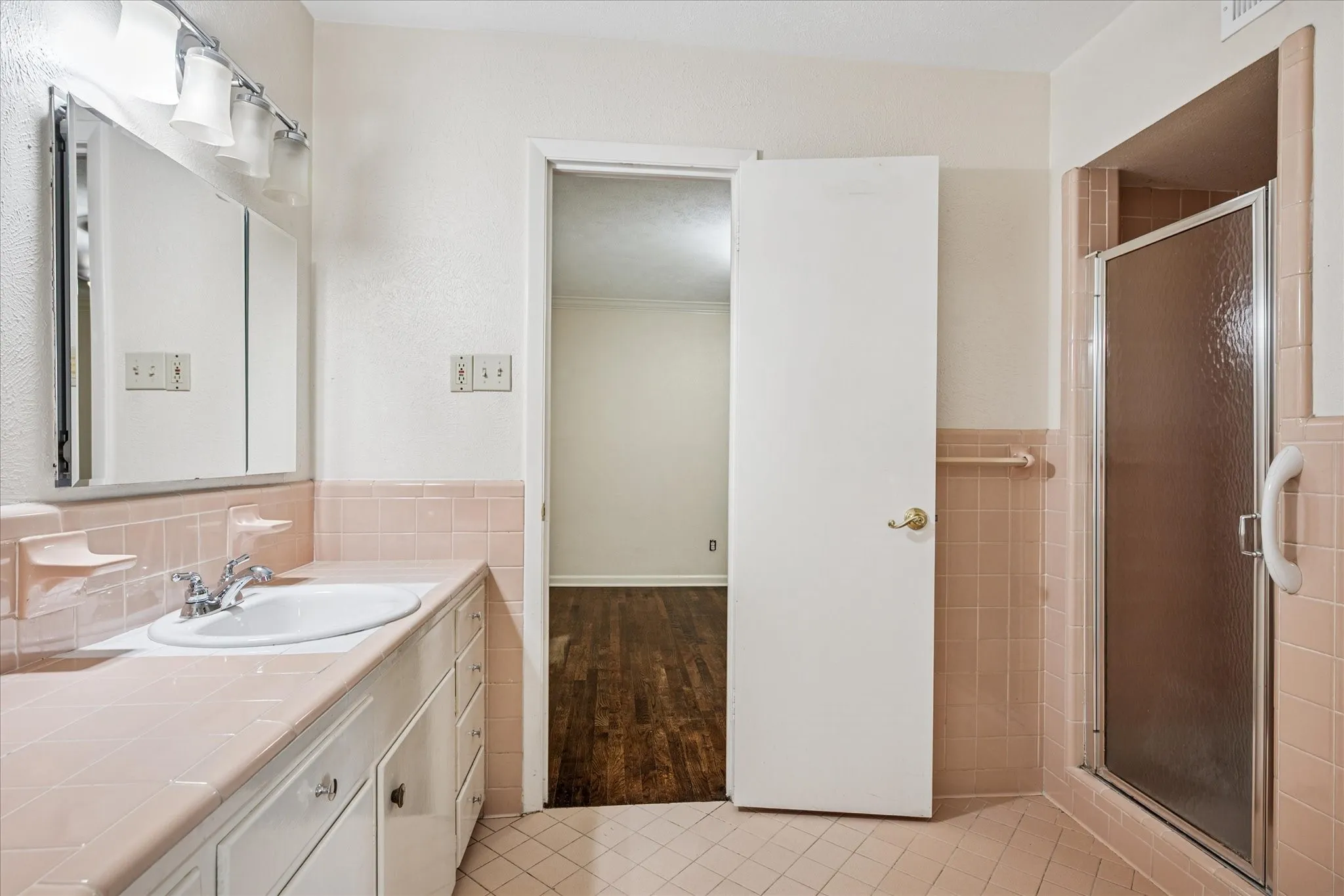 Apricot-colored tile jack and jill bath with shower.
