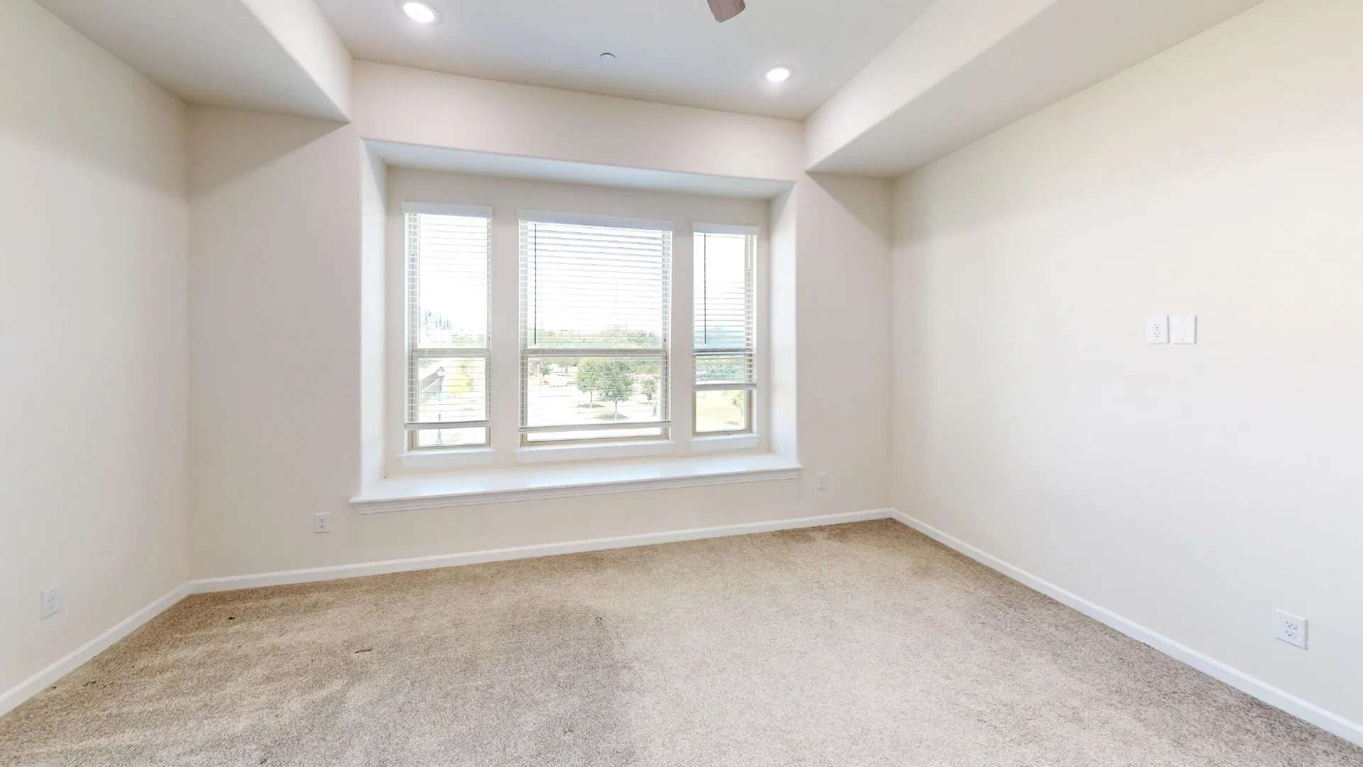 Recessed lighting, ceiling fan, neutral wall tones, bay window with integrated sill, and plush carpet flooring