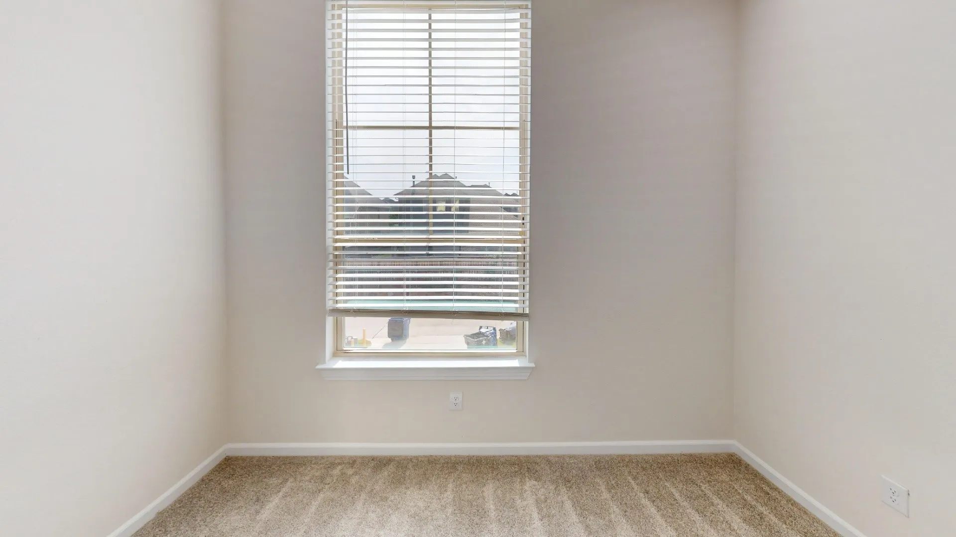Neutral tone wall paint, window with blinds, and neutral tone carpet