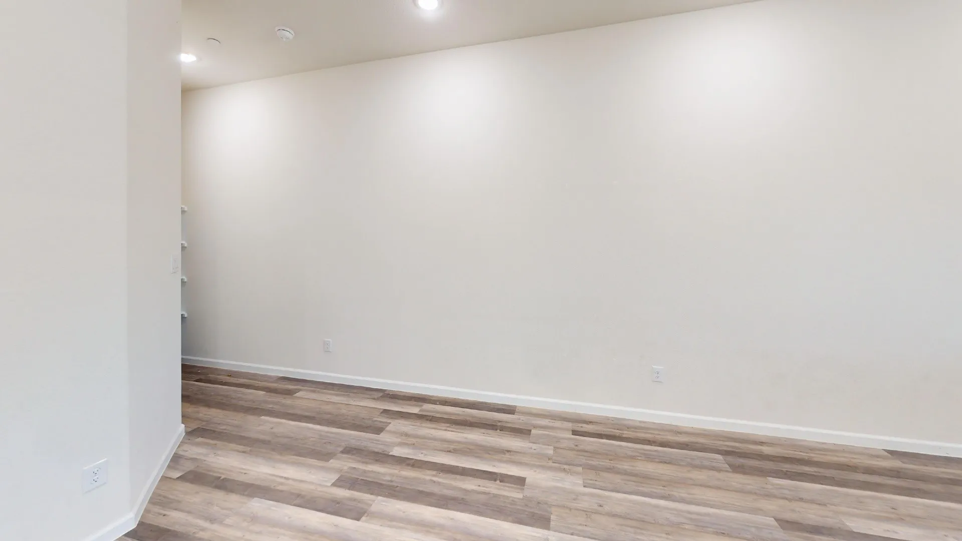 Recessed lighting, light wood-finish flooring, white walls, and built-in shelving