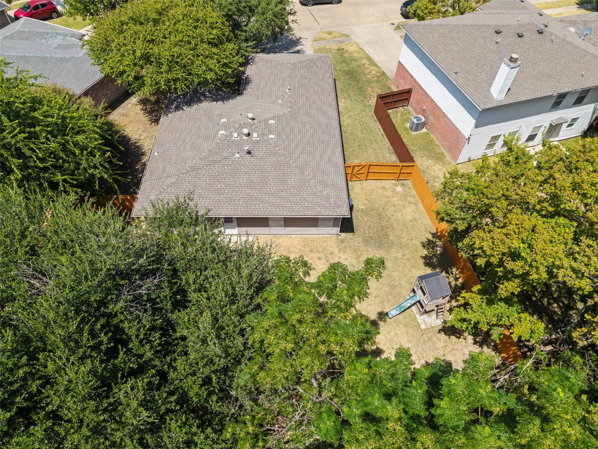 Expansive backyard featuring a new wood fence and mature trees