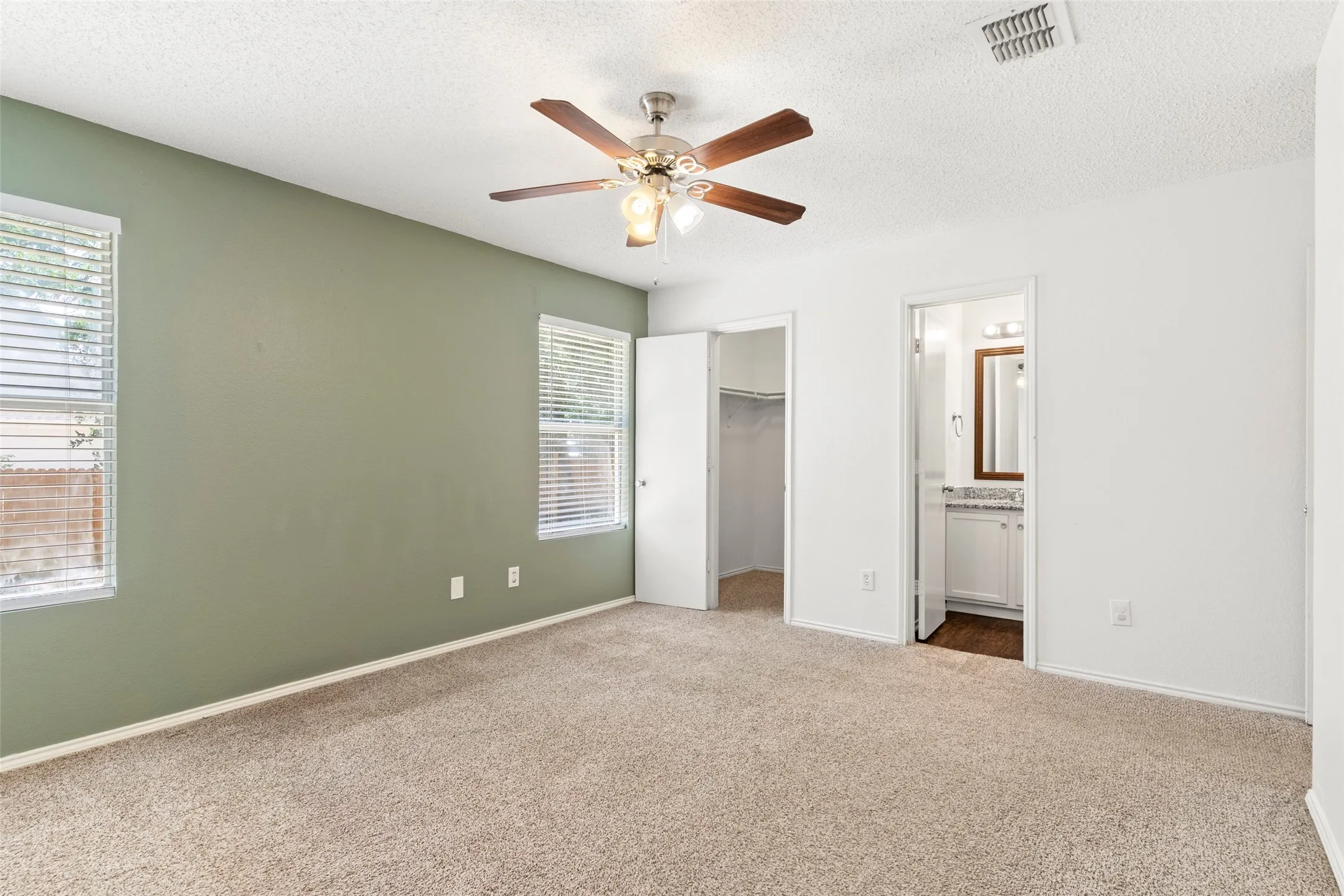 Plush carpeting and a ceiling fan with integrated lighting