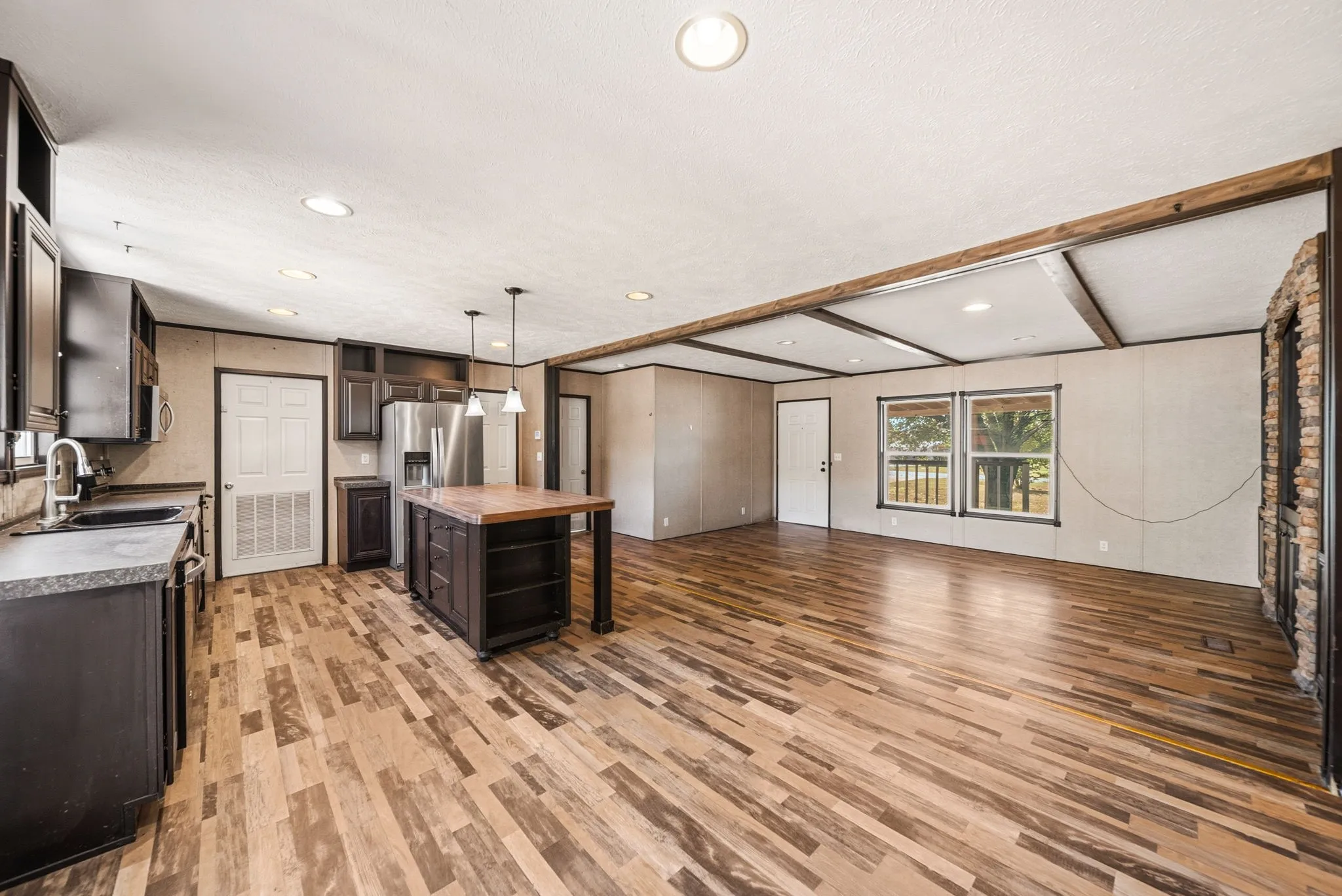 Expansive open-concept space featuring wood-finish flooring and recessed lighting