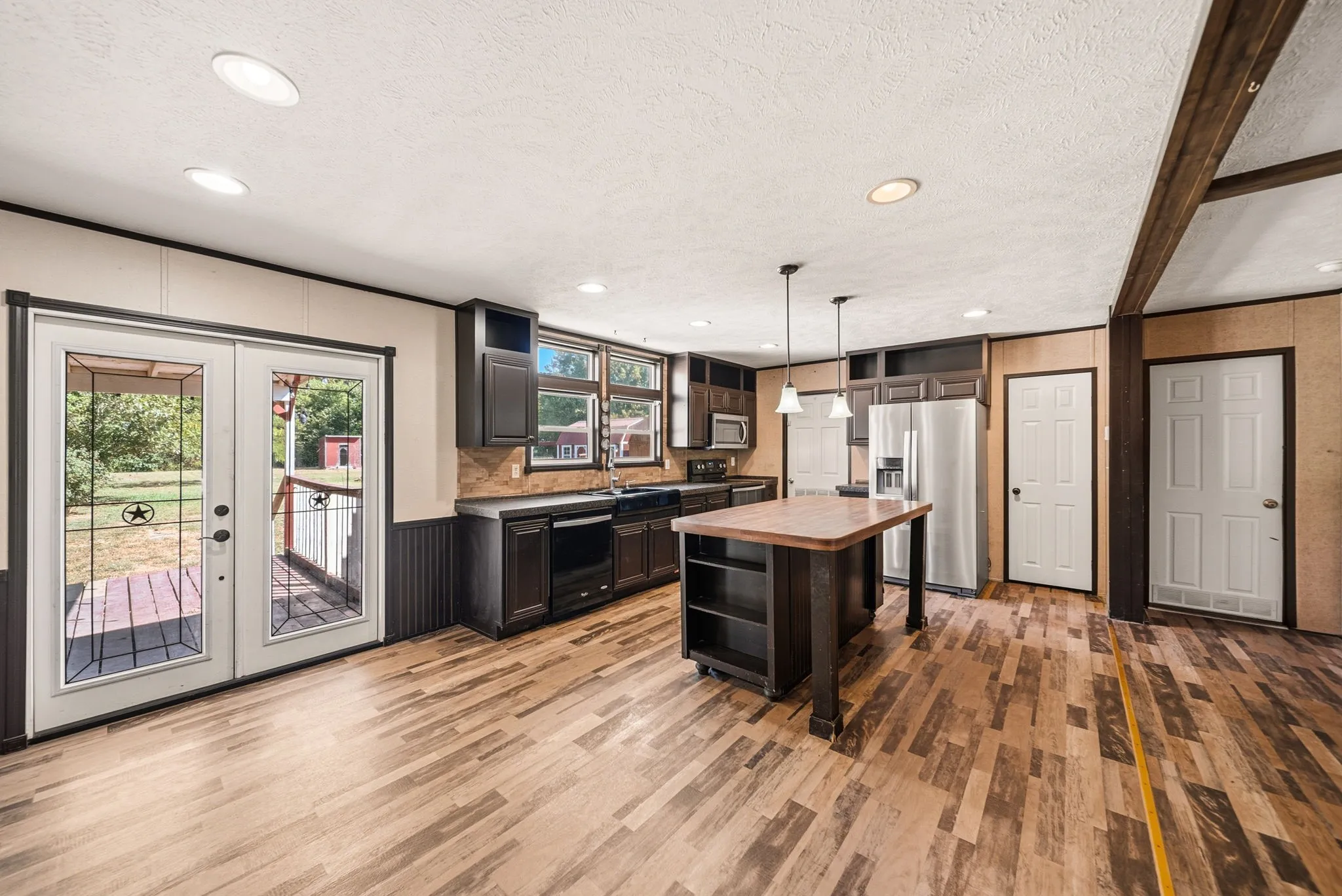 Kitchen featuring dark wood cabinetry, a central island with countertop, recessed lighting, and wood-finish flooring