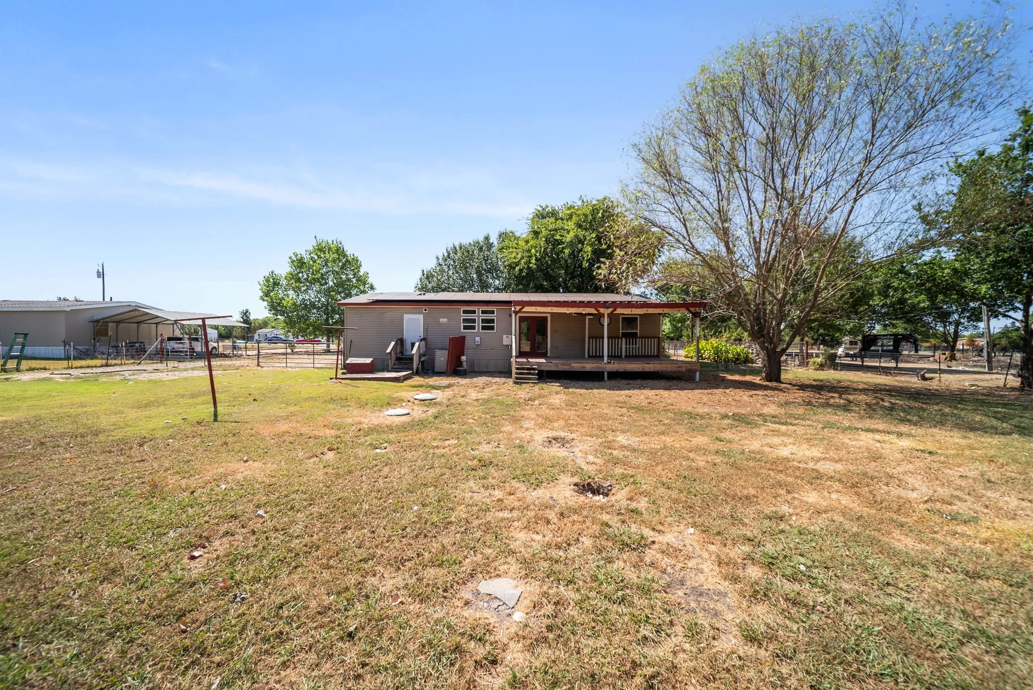 Expansive property with a covered porch and mature trees