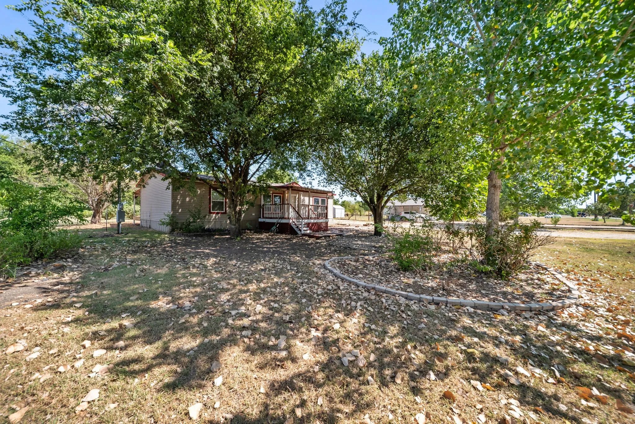 Expansive front yard with mature trees providing ample shade