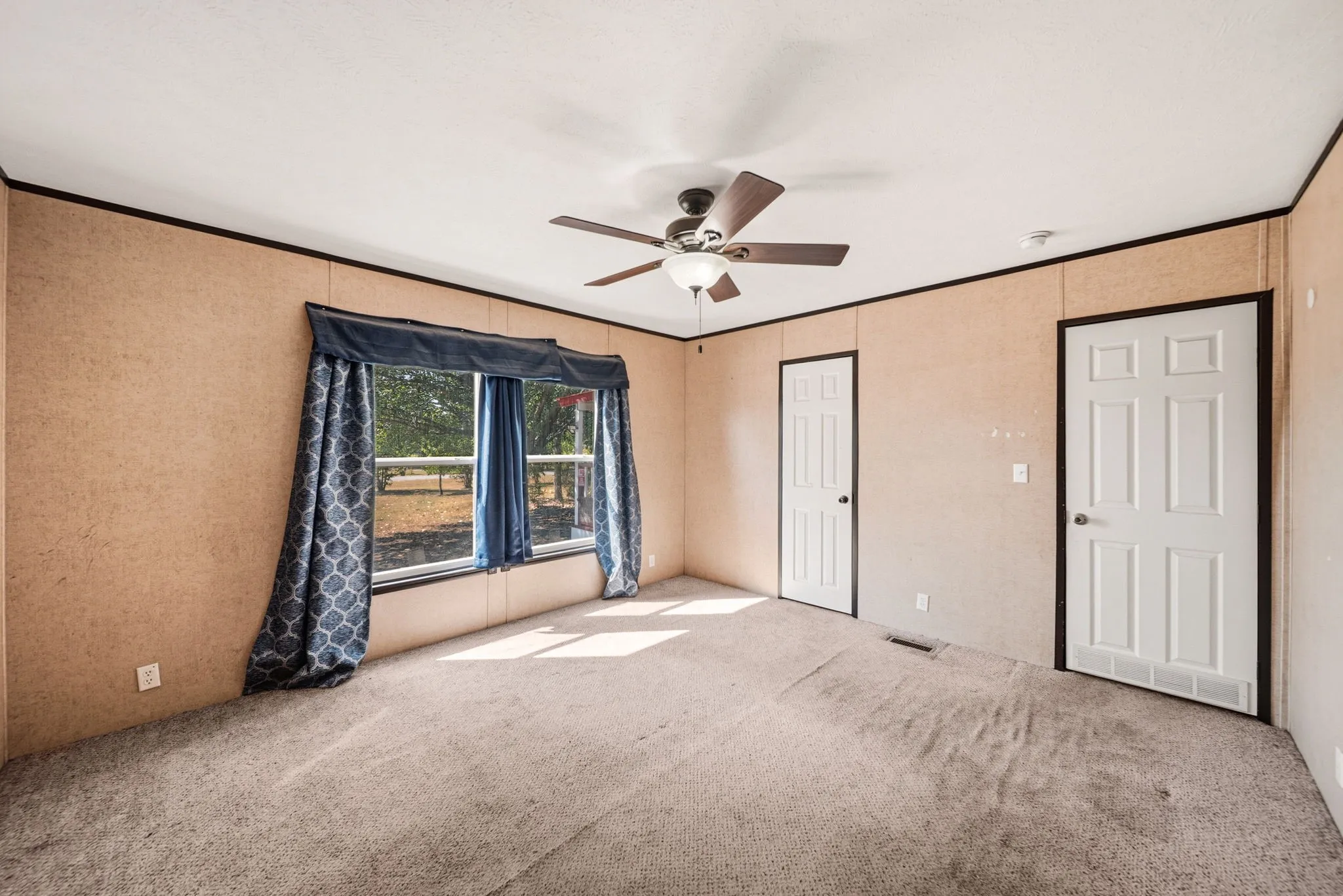 Carpeted flooring with dual pane windows, ceiling fan, and two paneled doors