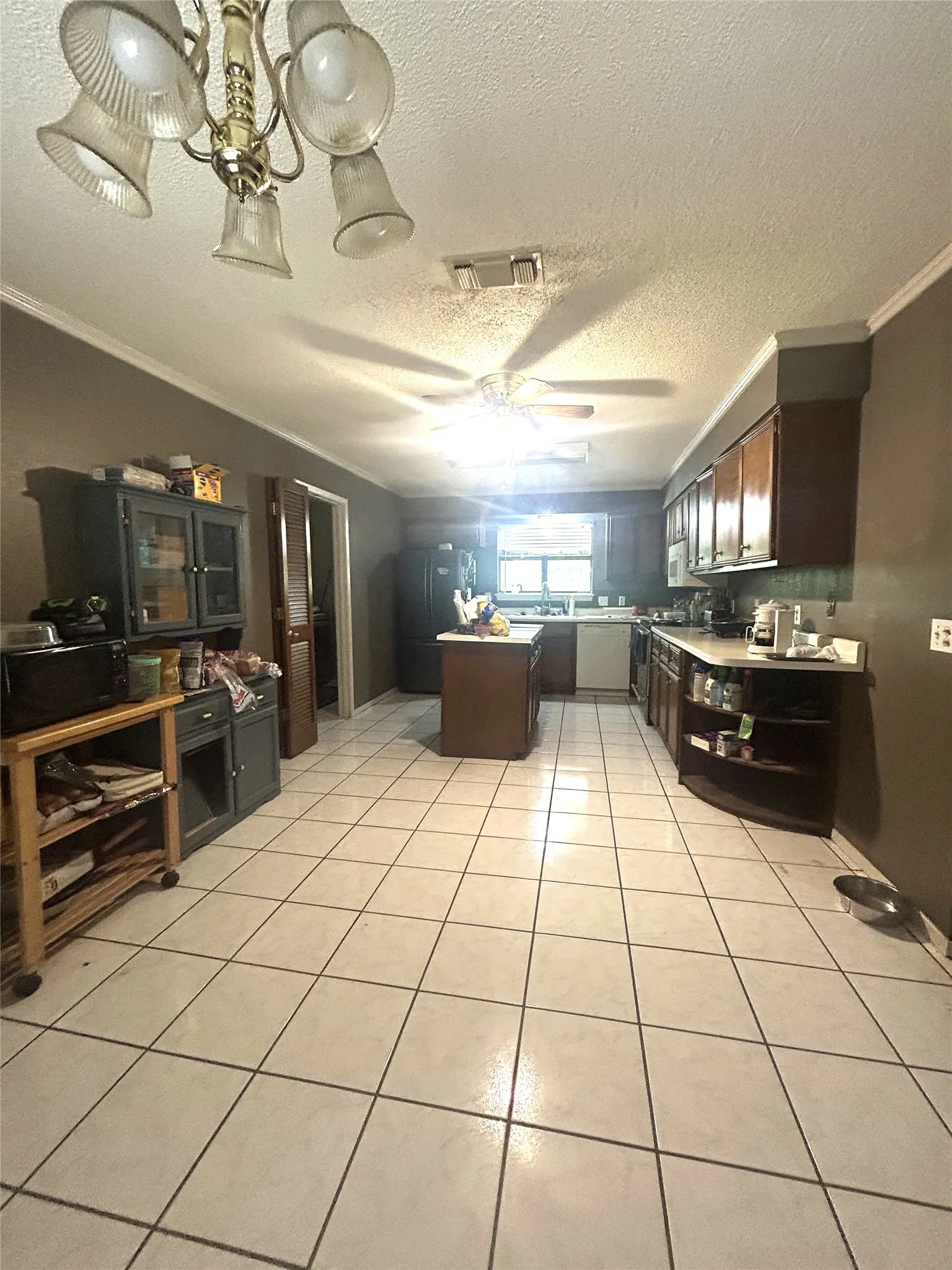 Dining area looking toward kitchen with ceiling fan and tile floors