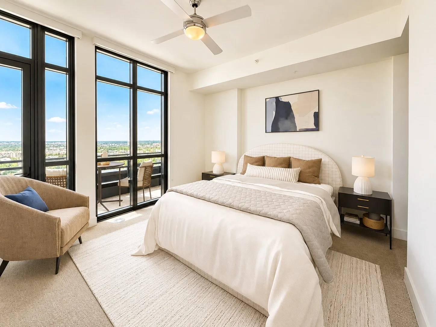 Full-height windows, a ceiling fan, a private balcony, and plush carpeting