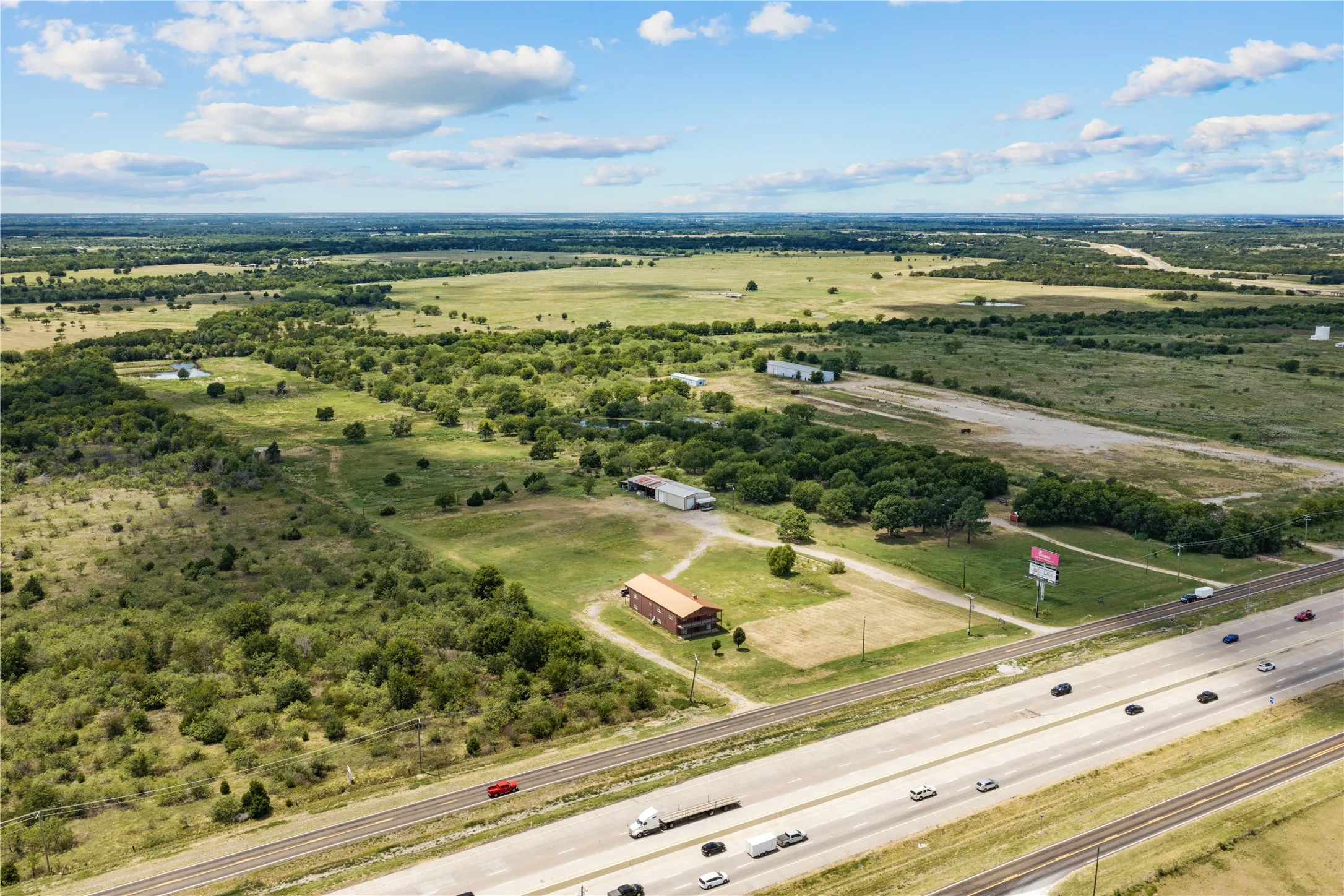 Expansive property featuring a multi-lane highway, railway lines, and various structures