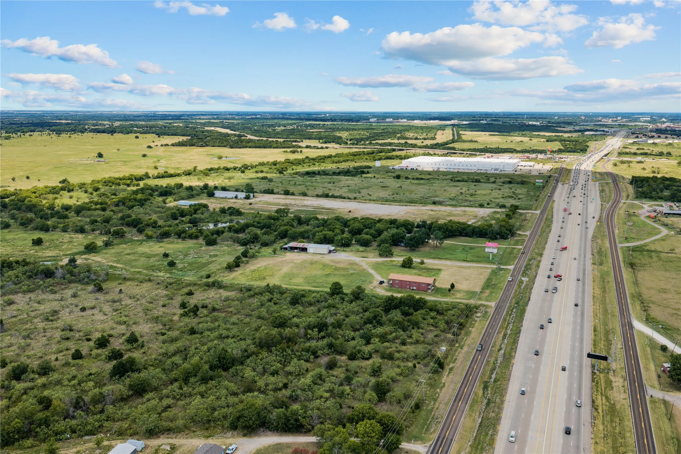 Expansive green spaces and natural terrain characterize the surrounding area