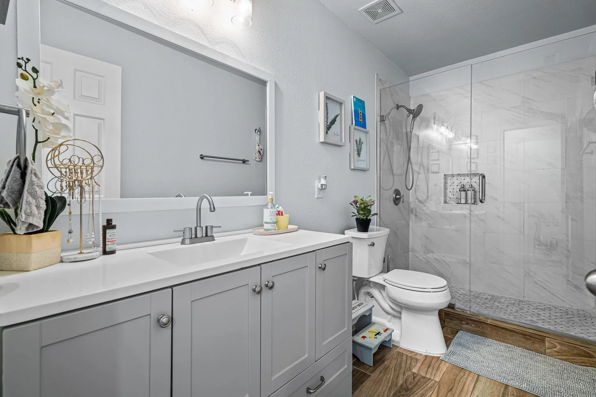 Spacious vanity with light gray cabinetry and white countertop