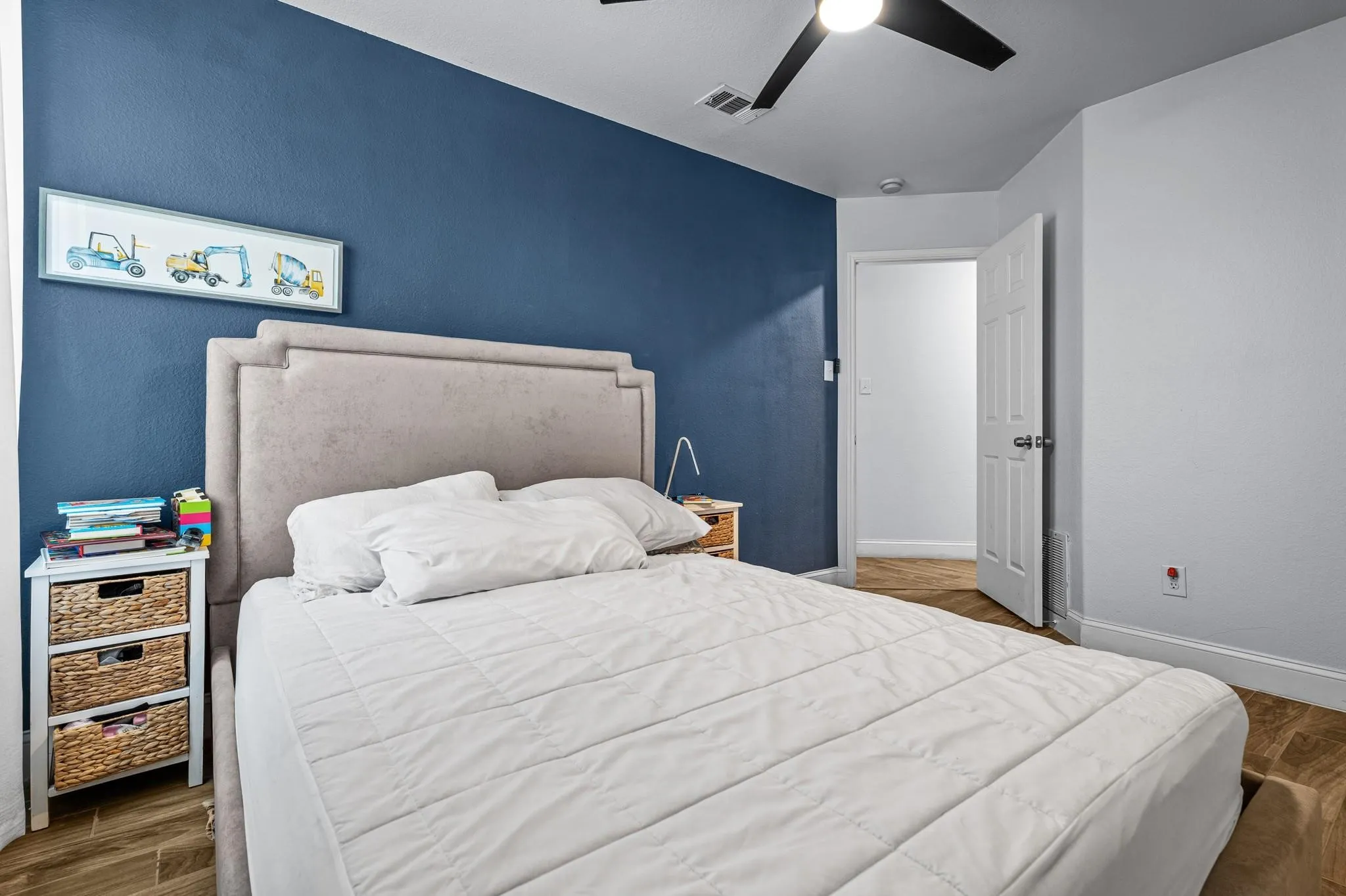 Accent wall, ceiling fan, wood-finish flooring, white trim, white paneled door