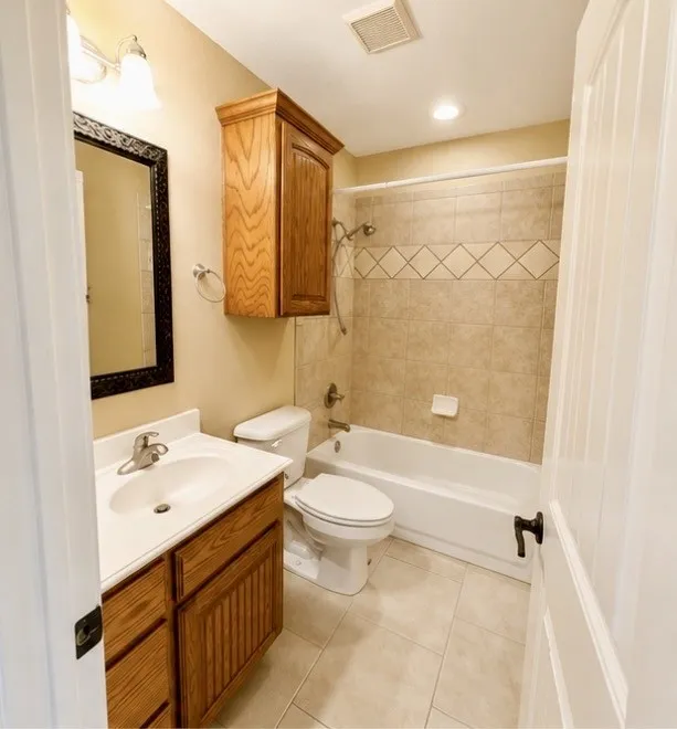 White vanity with integrated sink, wood-finish cabinetry, and single-handle faucet